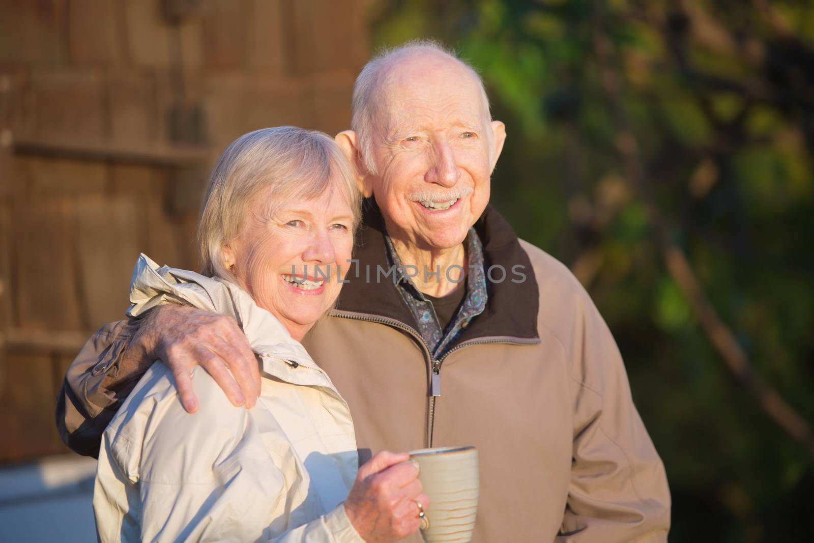 Cheerful couple standing outdoors with coffee mug