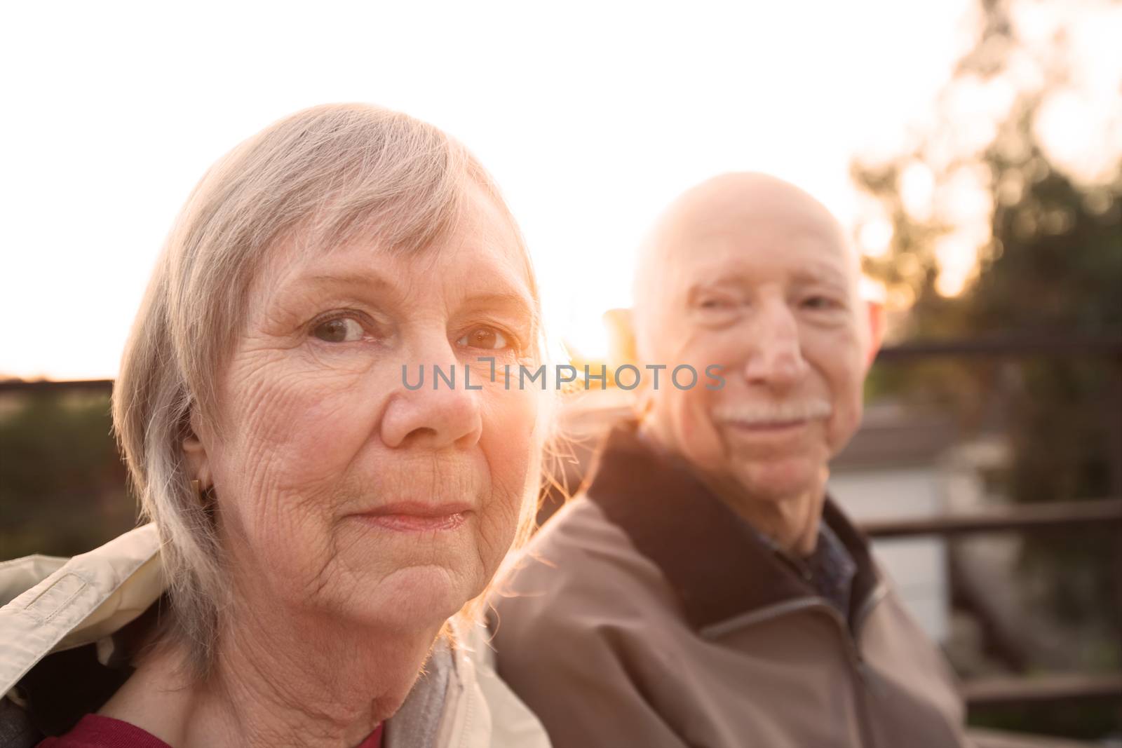 Calm Caucasian senior couple sitting together outdoors