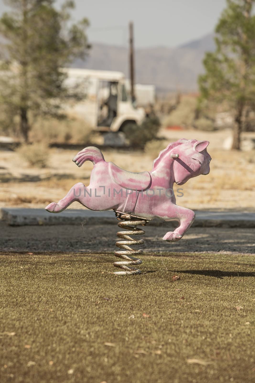 Rusty and faded ride for children on disused playground