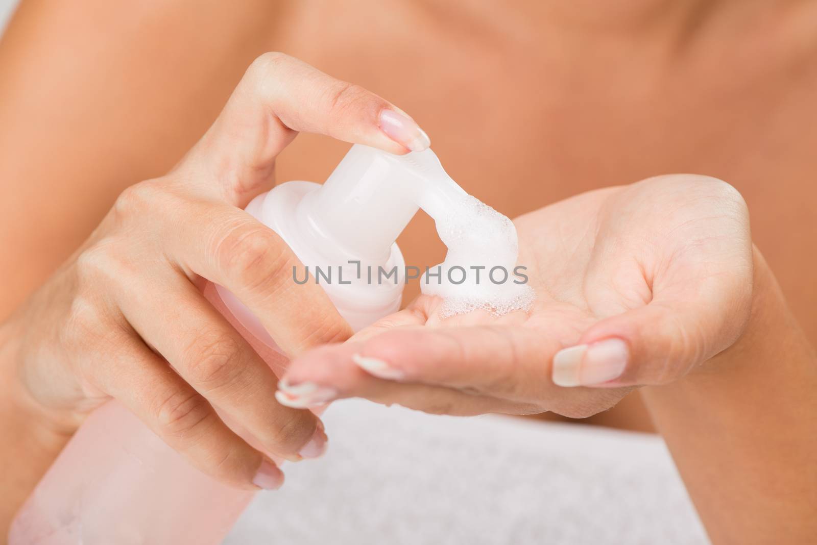 Close-up of moisturizing foam cleaning face in the hands of a young woman, unrecognizable face with a underwear. Selective focus.