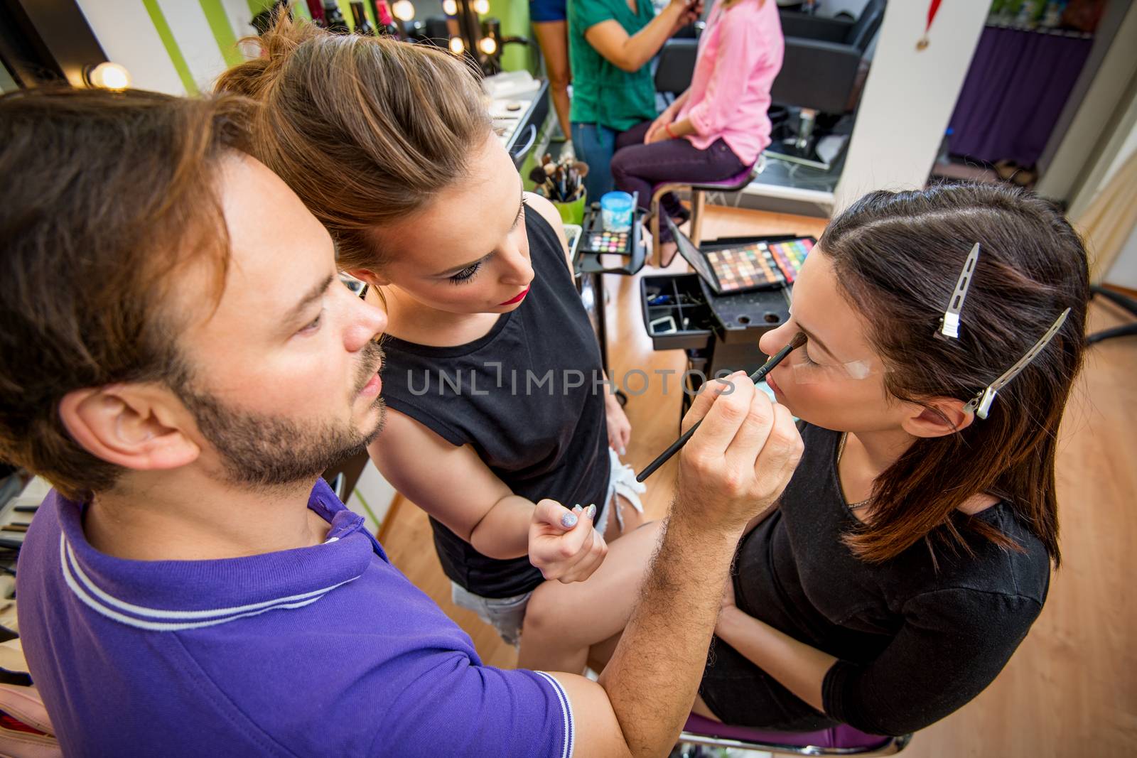 Makeup teacher helping students training to become makeup artist