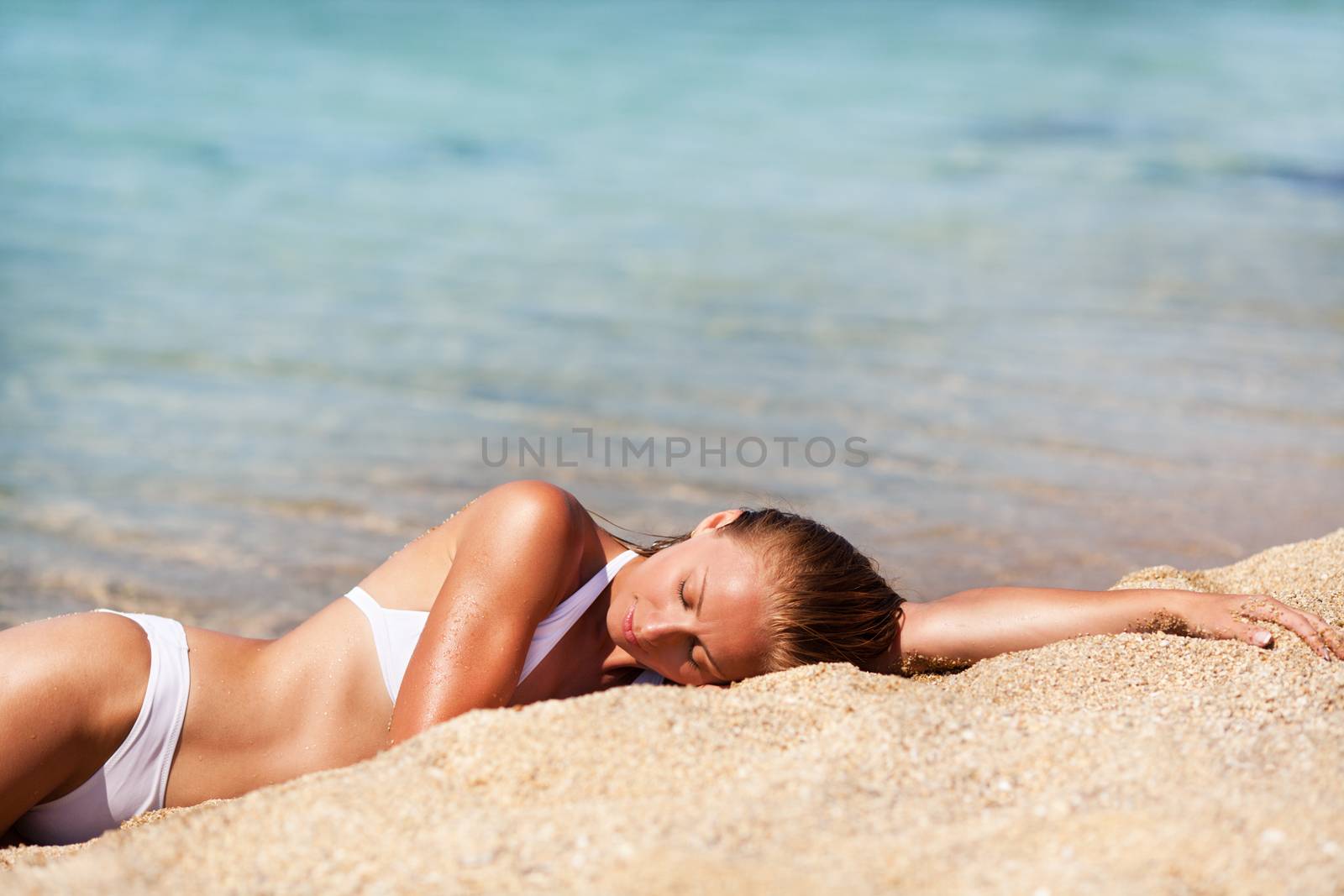 Young beautiful woman enjoying and relaxing on the sand beach