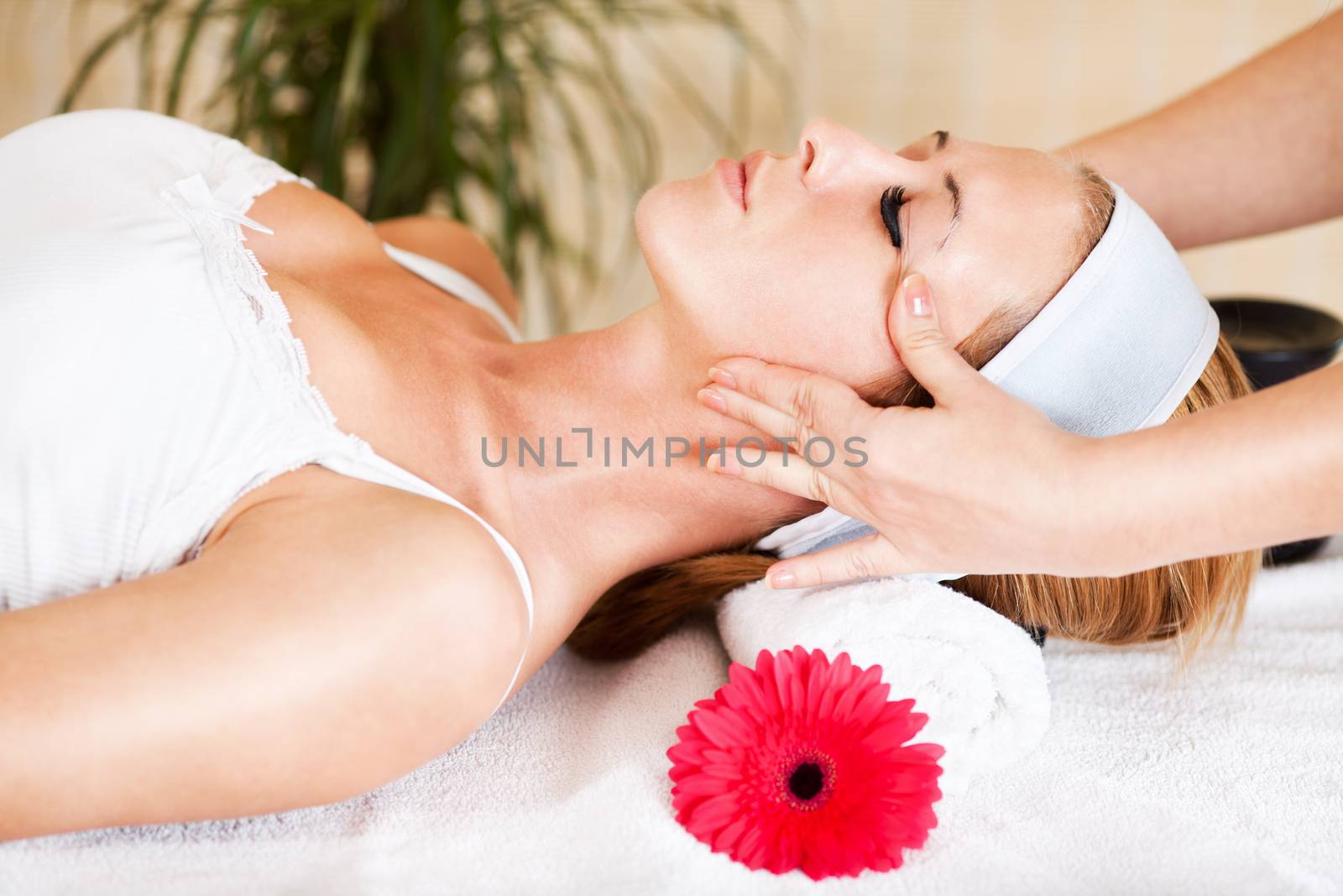 Young beautiful woman receiving head massage at the spa center