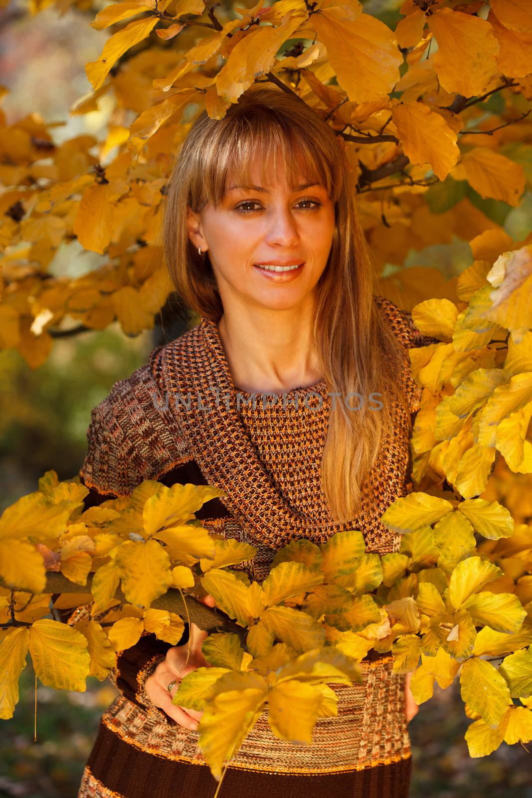 Young beautiful woman united with nature in autumn