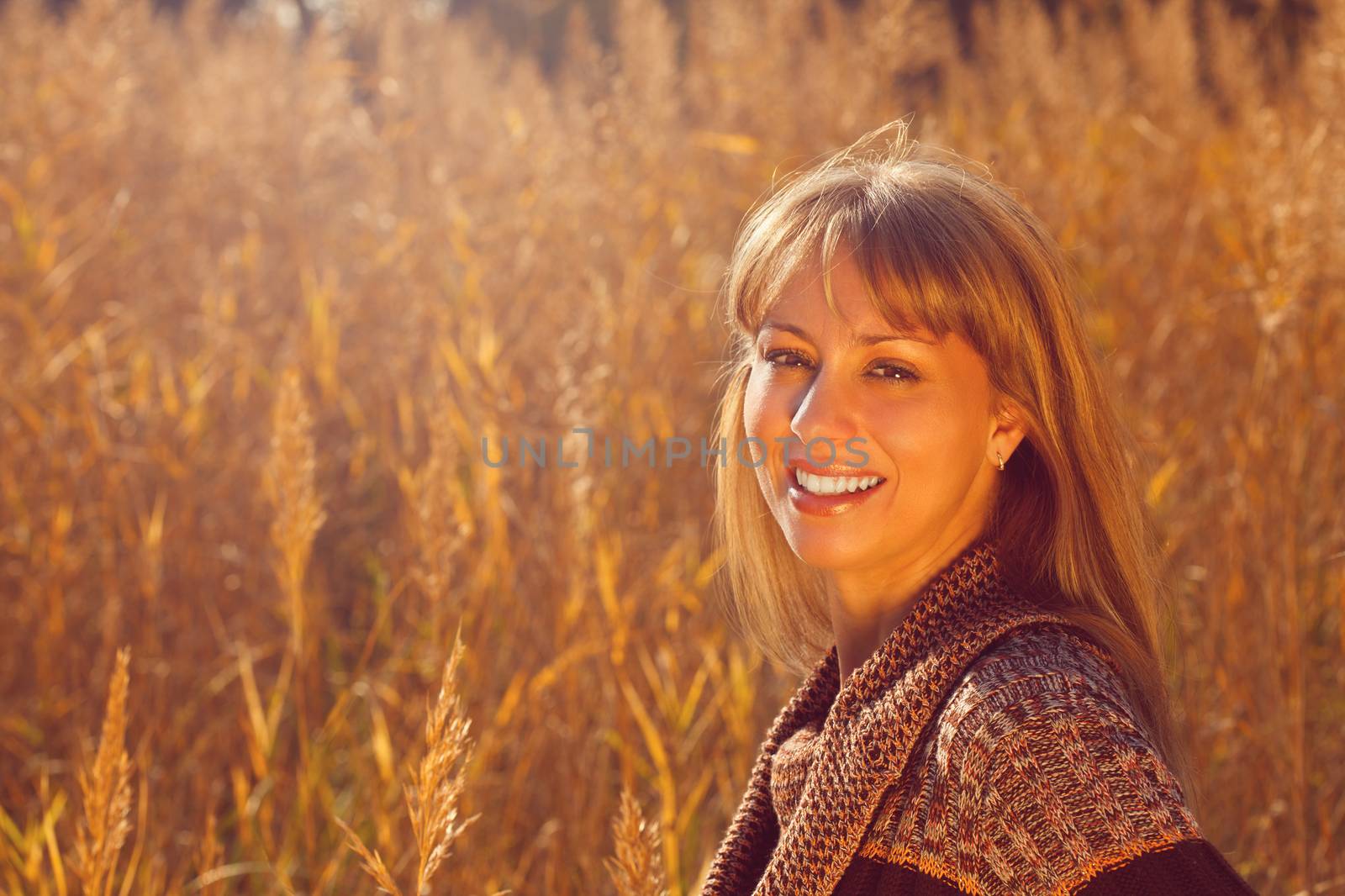 Young beautiful autumn woman lighted by the sun