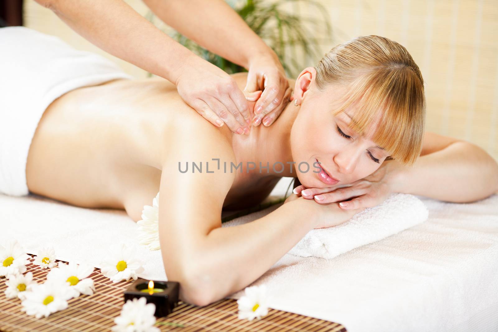 Young beautiful woman receiving back massage at the spa center