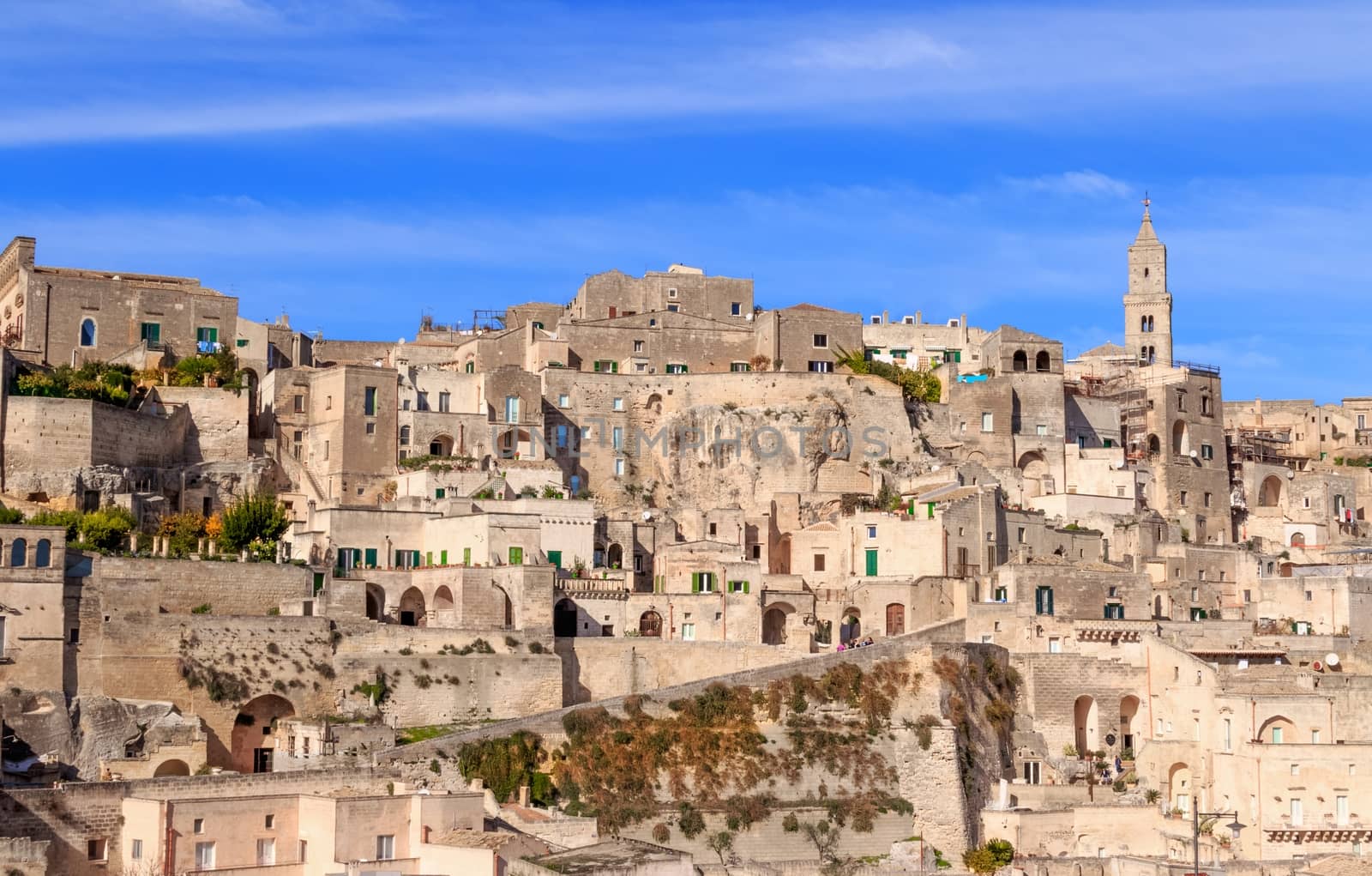 panoramic view of typical stones (Sassi di Matera) and church of Matera under blue sky. Basilicata, Italy