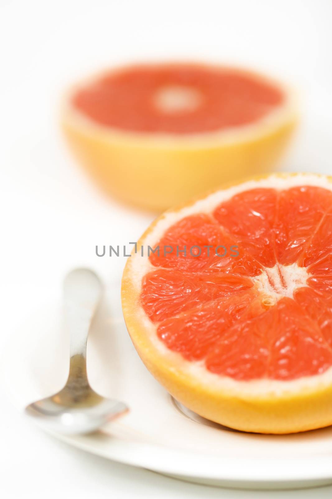 Halved red grapefruit on the plate