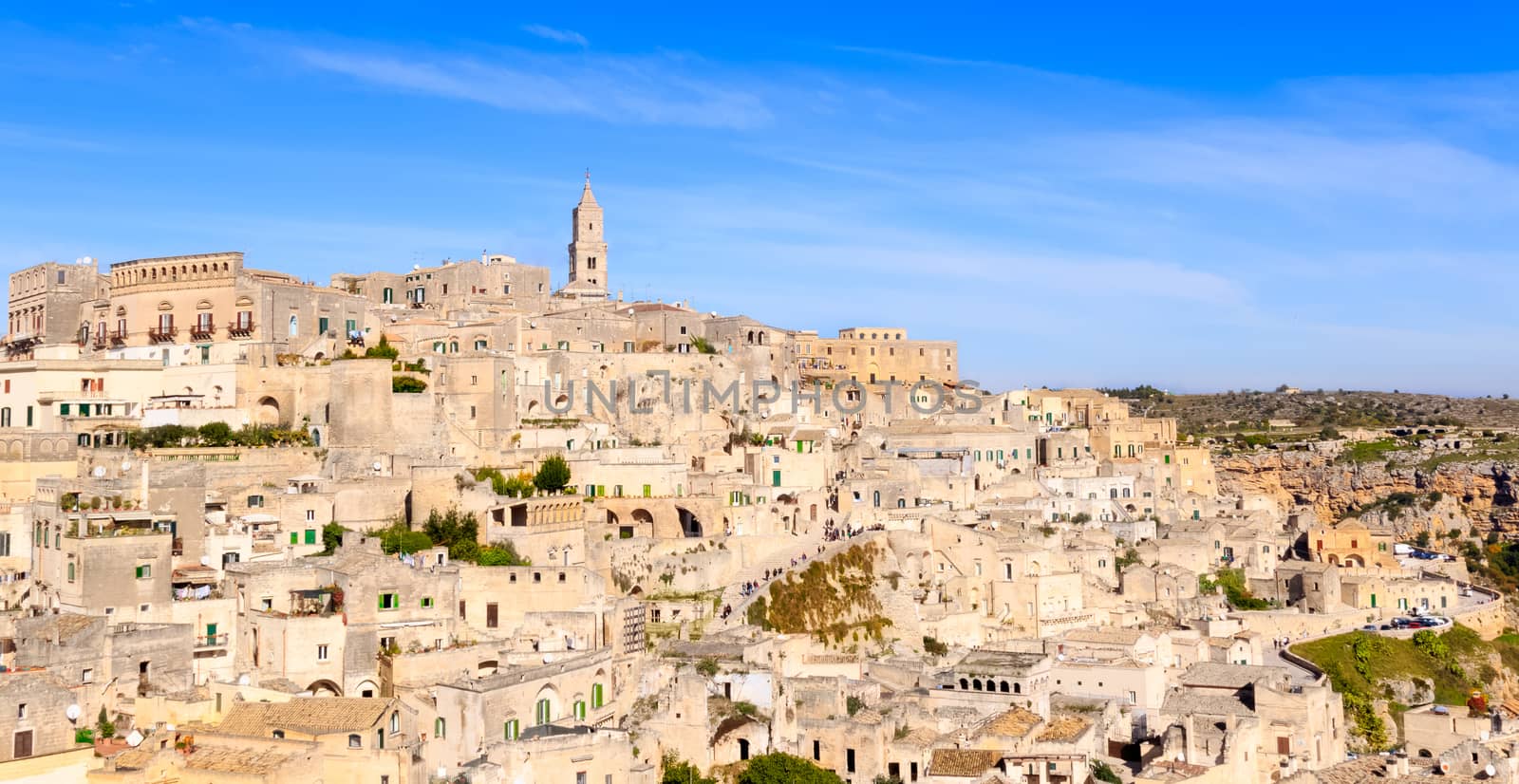 panoramic view of typical stones (Sassi di Matera) and church of Matera under blue sky. Basilicata, Italy