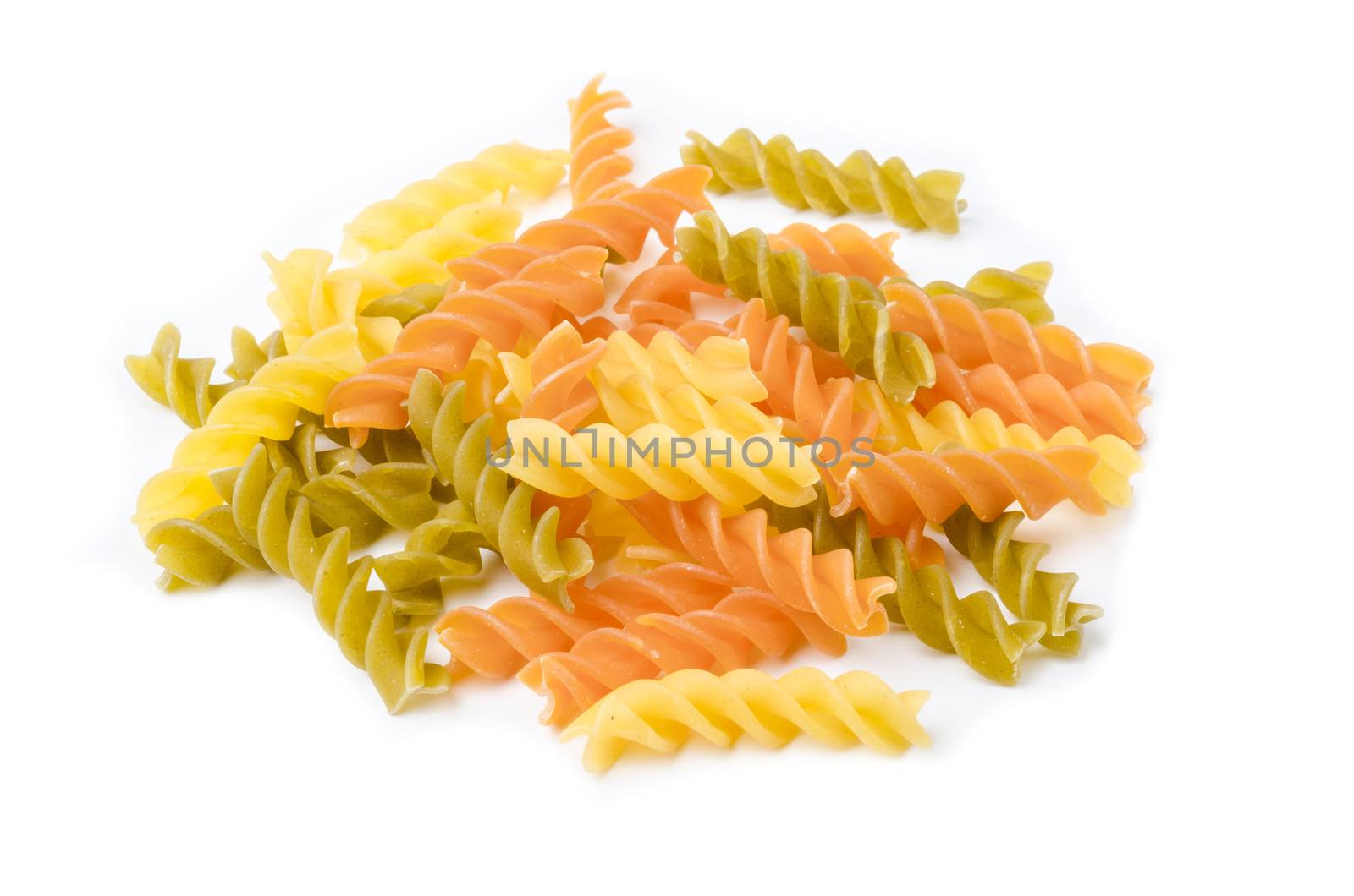 Uncooked italian pasta - three colors spirals on white background.