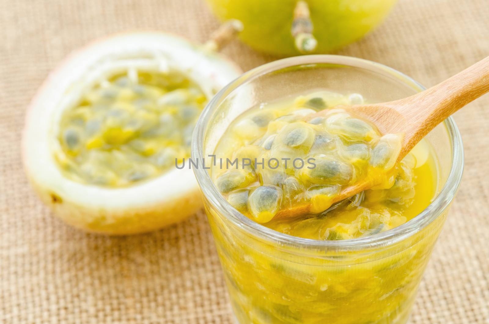 Passion fruit juice in glass and fresh passion fruit on sack background.