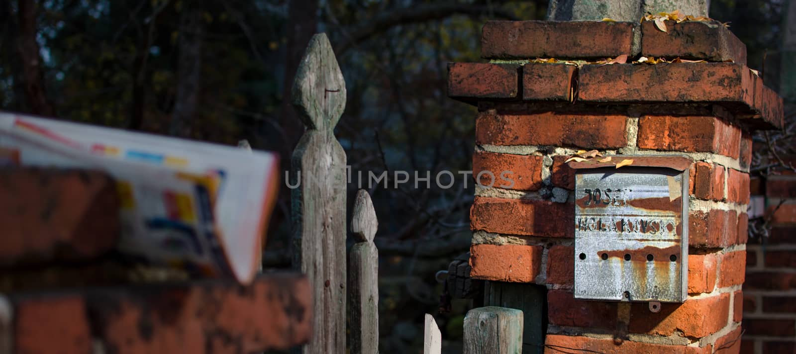 Very old rusty post box on the brick column.