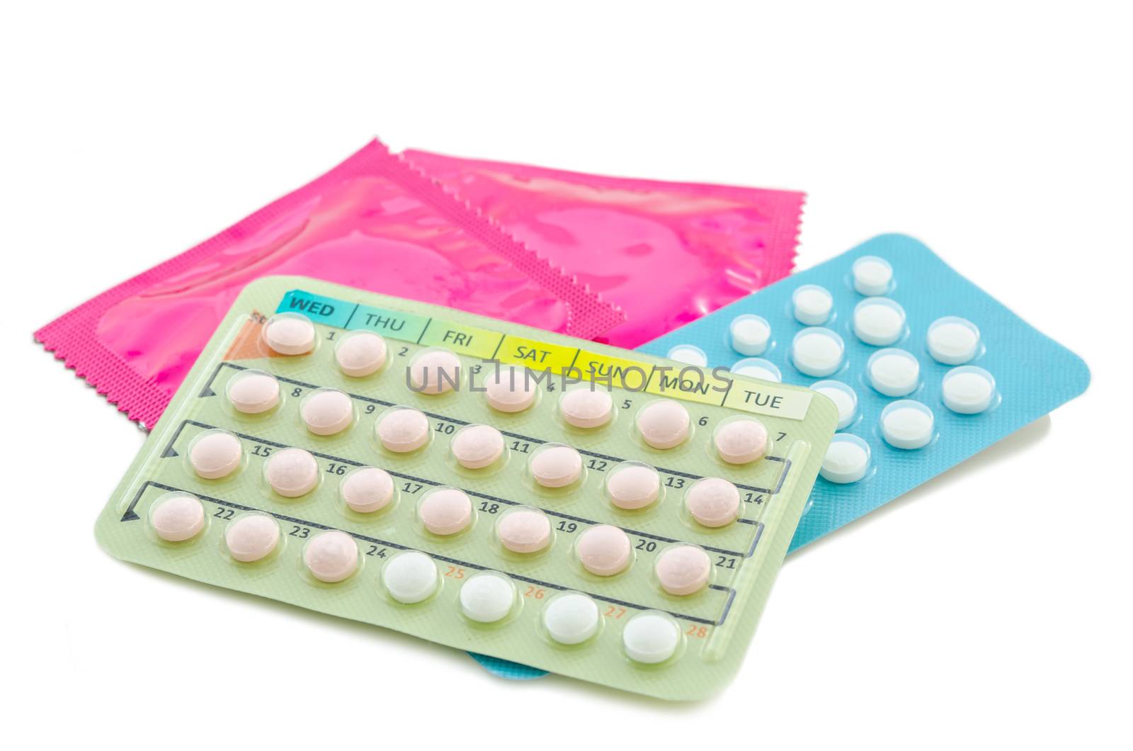 Strip of Contraceptive Pill and condoms on white background.