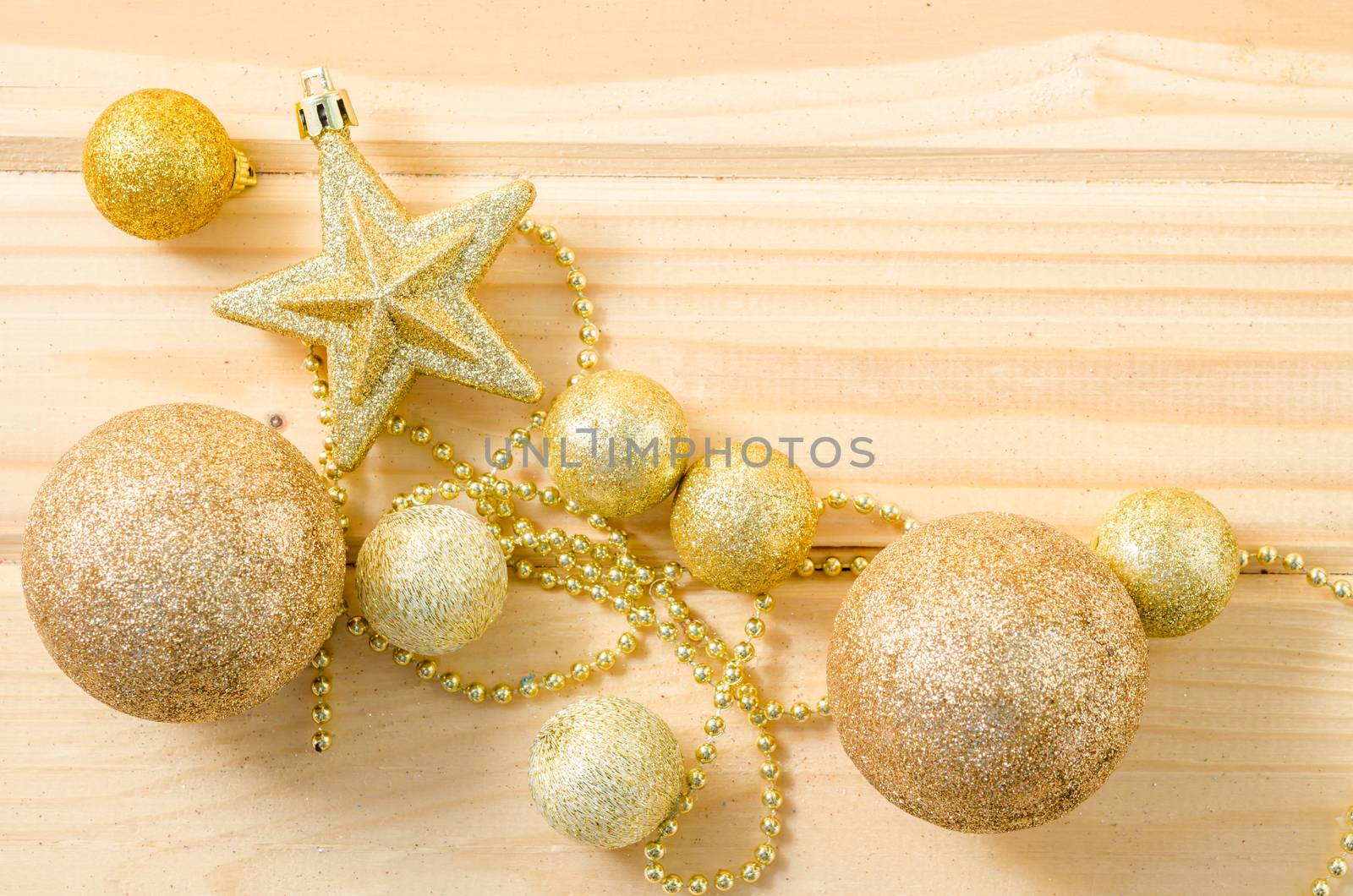 Golden Christmas decorations on wooden background.