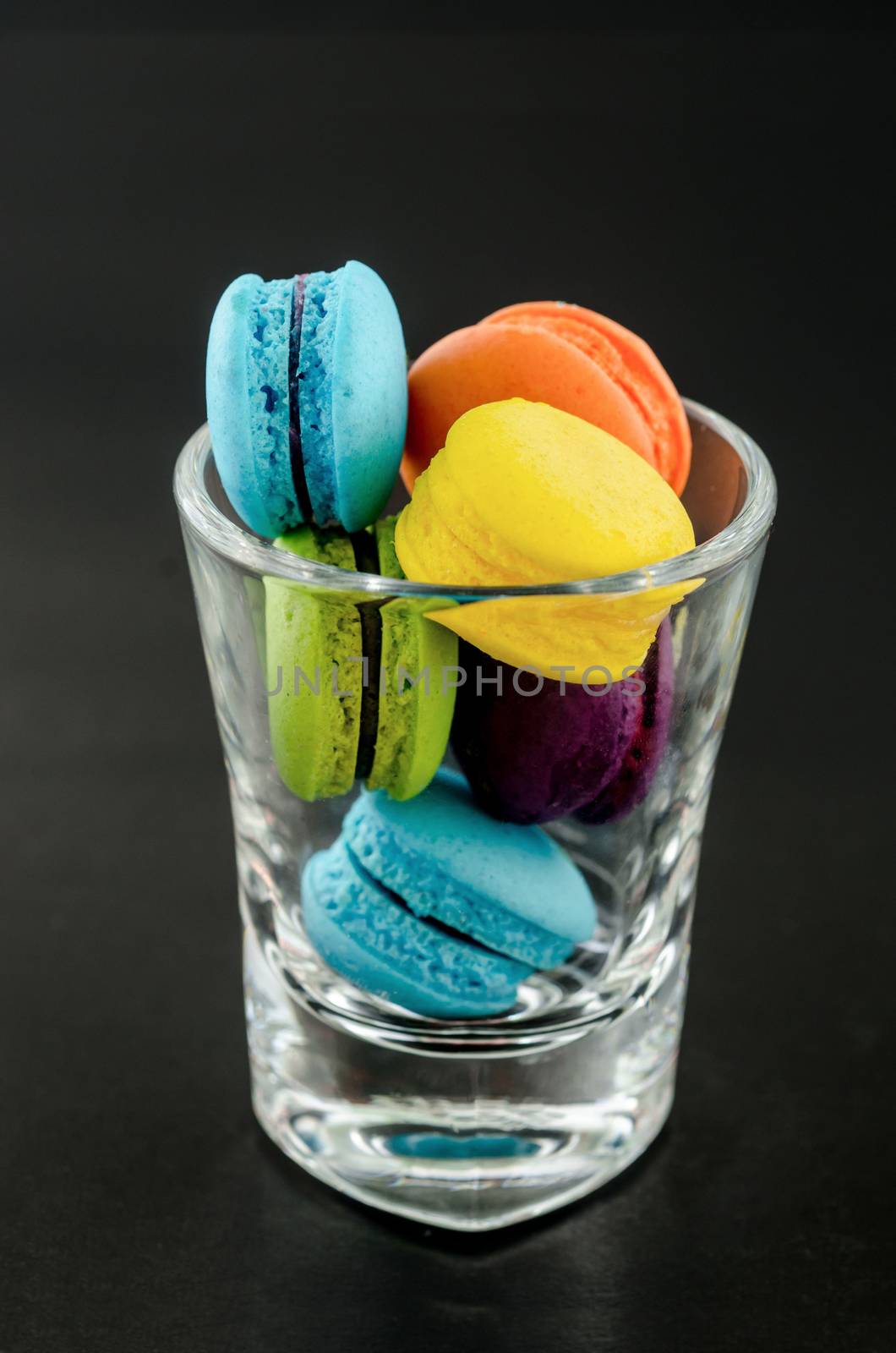 Sweet and colorful french macaroons in glass. by Gamjai