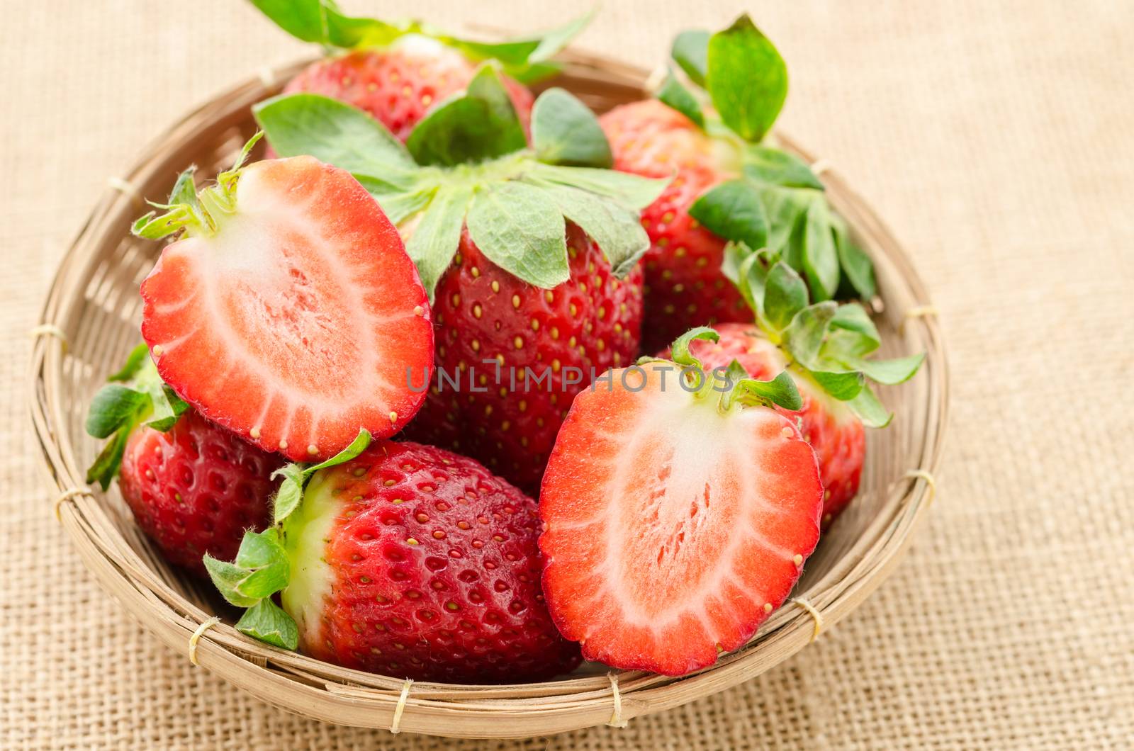 Fresh strawberries in weave basket. by Gamjai
