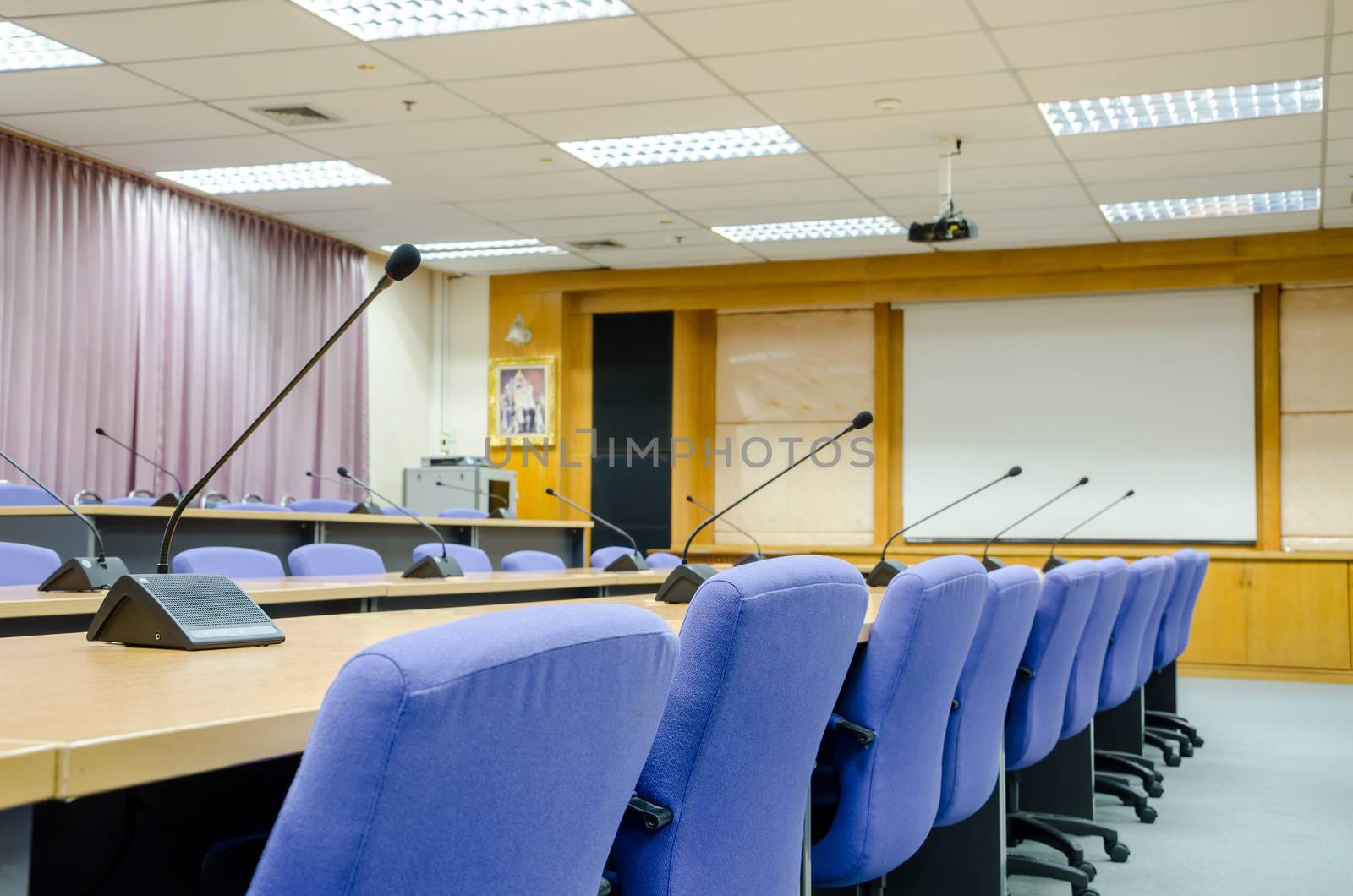 The microphones in front of empty chairs in meeting room. by Gamjai