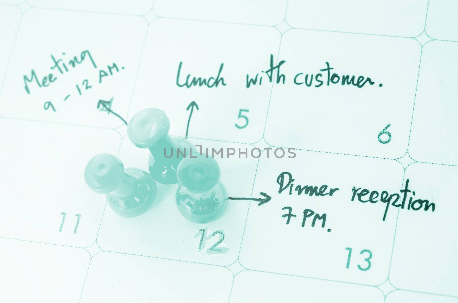 Pushpin on calendar with busy day overworked schedule.