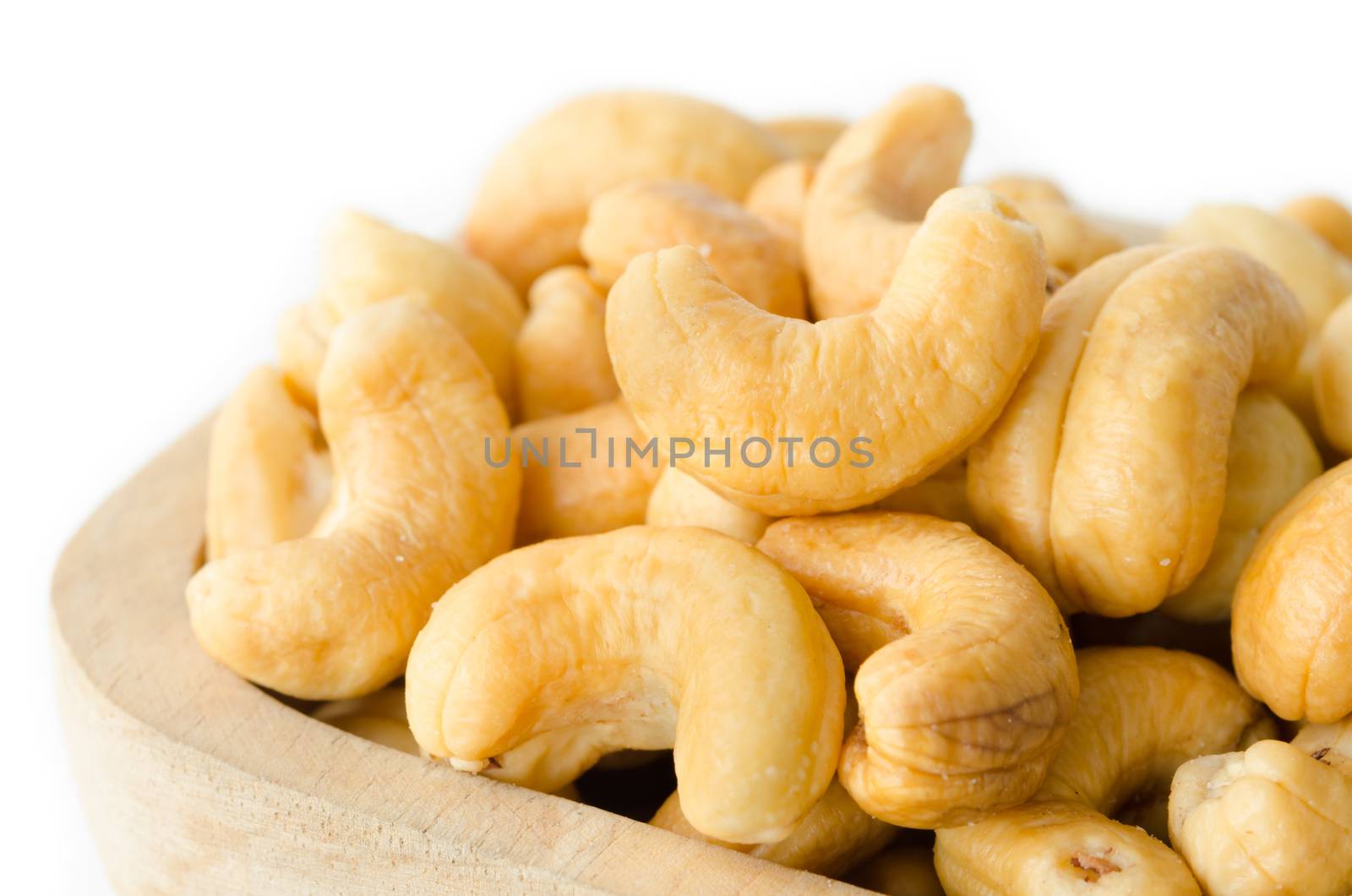 Cashew in wooden bowl on white background.