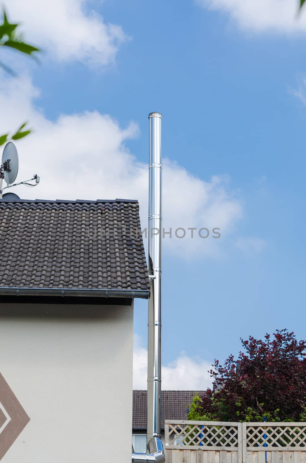 Precious steel chimney on the side wall of a residential building. To connect a wood-burning stove.