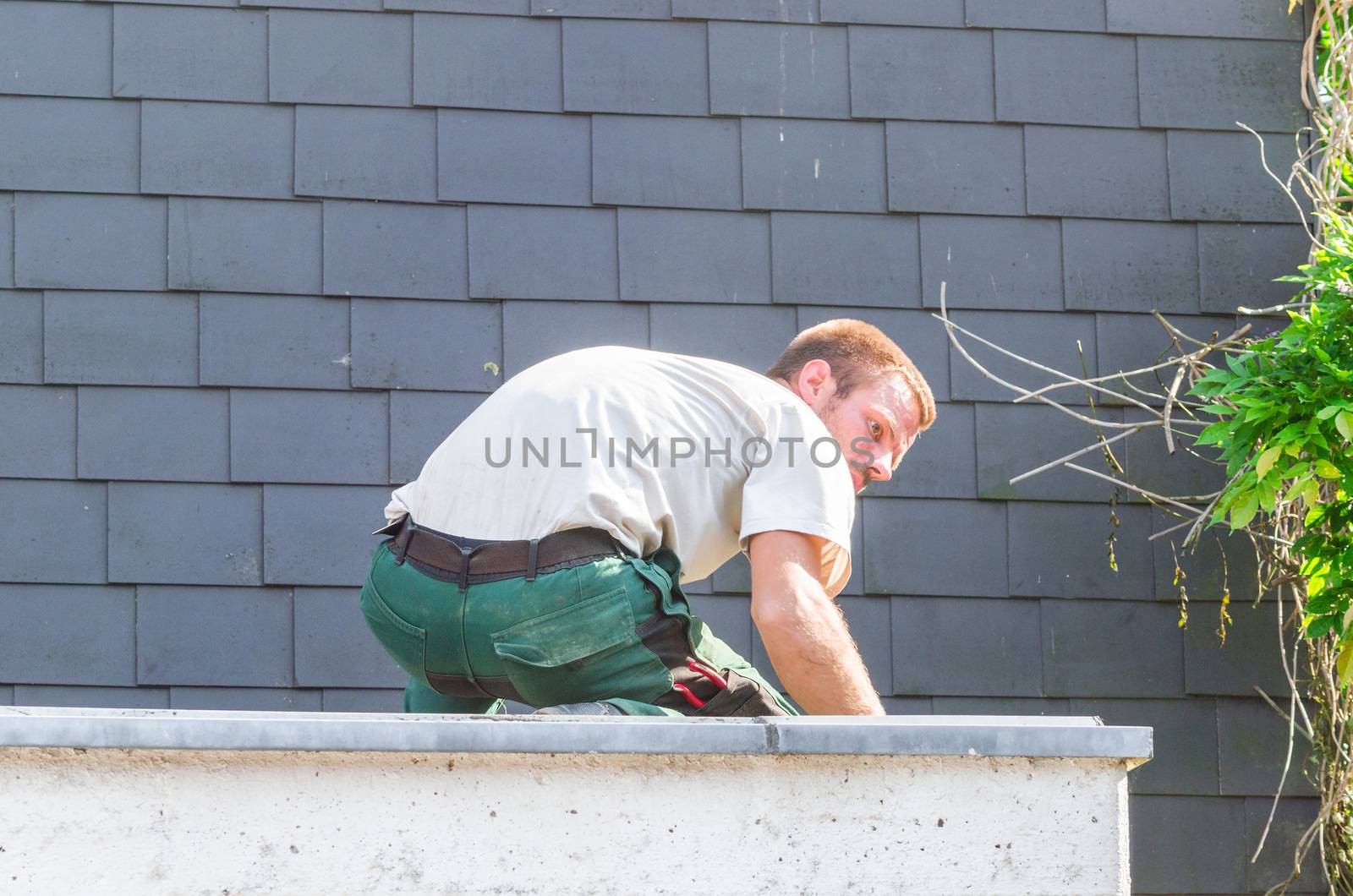 Portrait repairman at work repairing roof