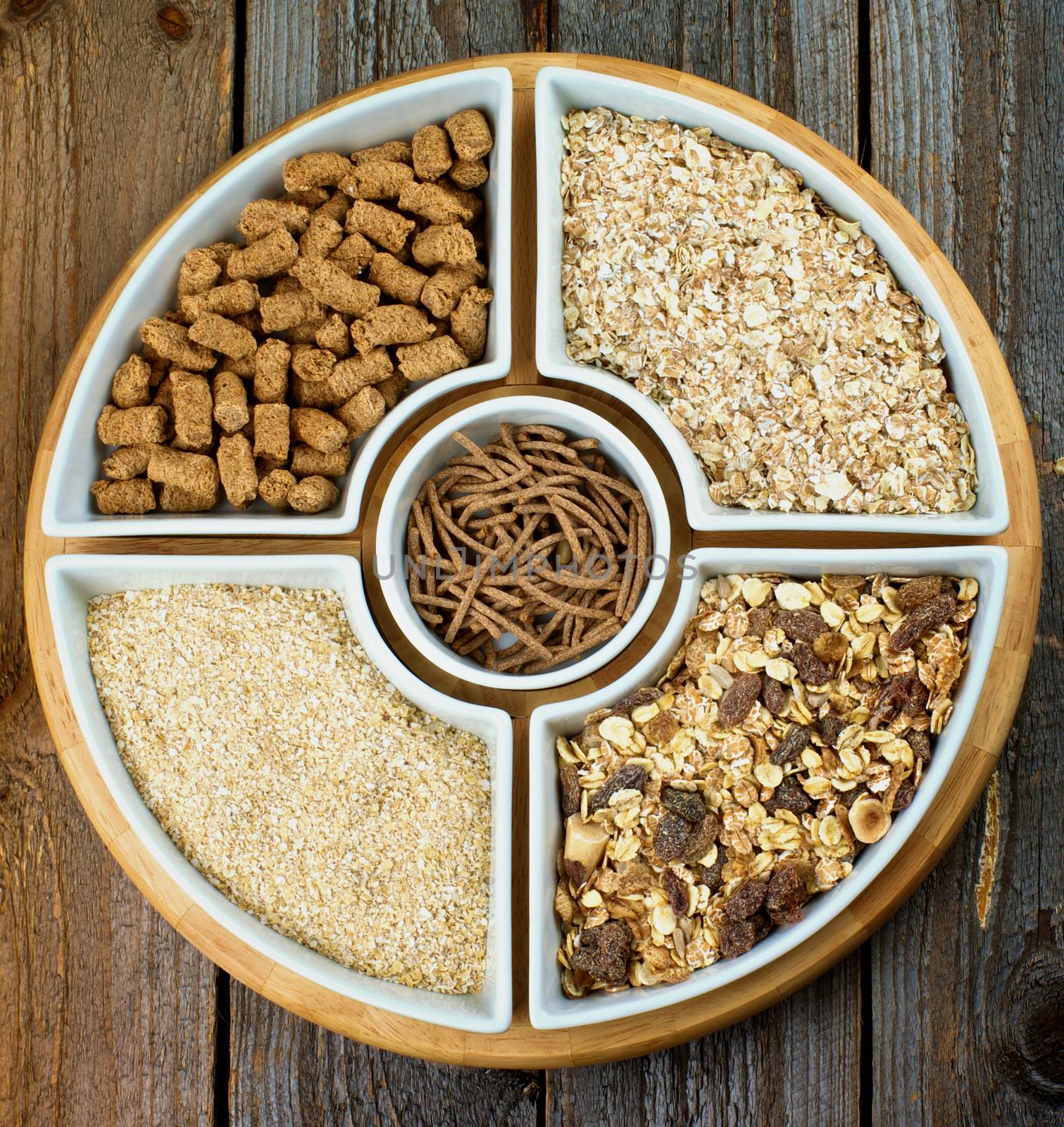 Various Oat Flakes, Muesli and Bran in White Bowls closeup on Rustic Wooden background. Top View