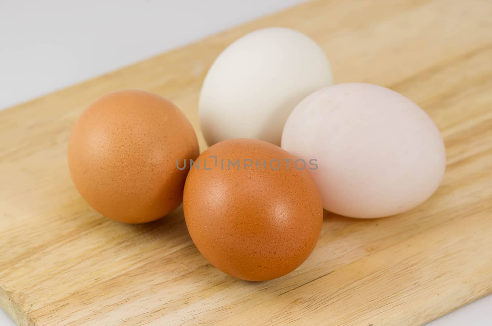 Eggs on wood background. by seksan44