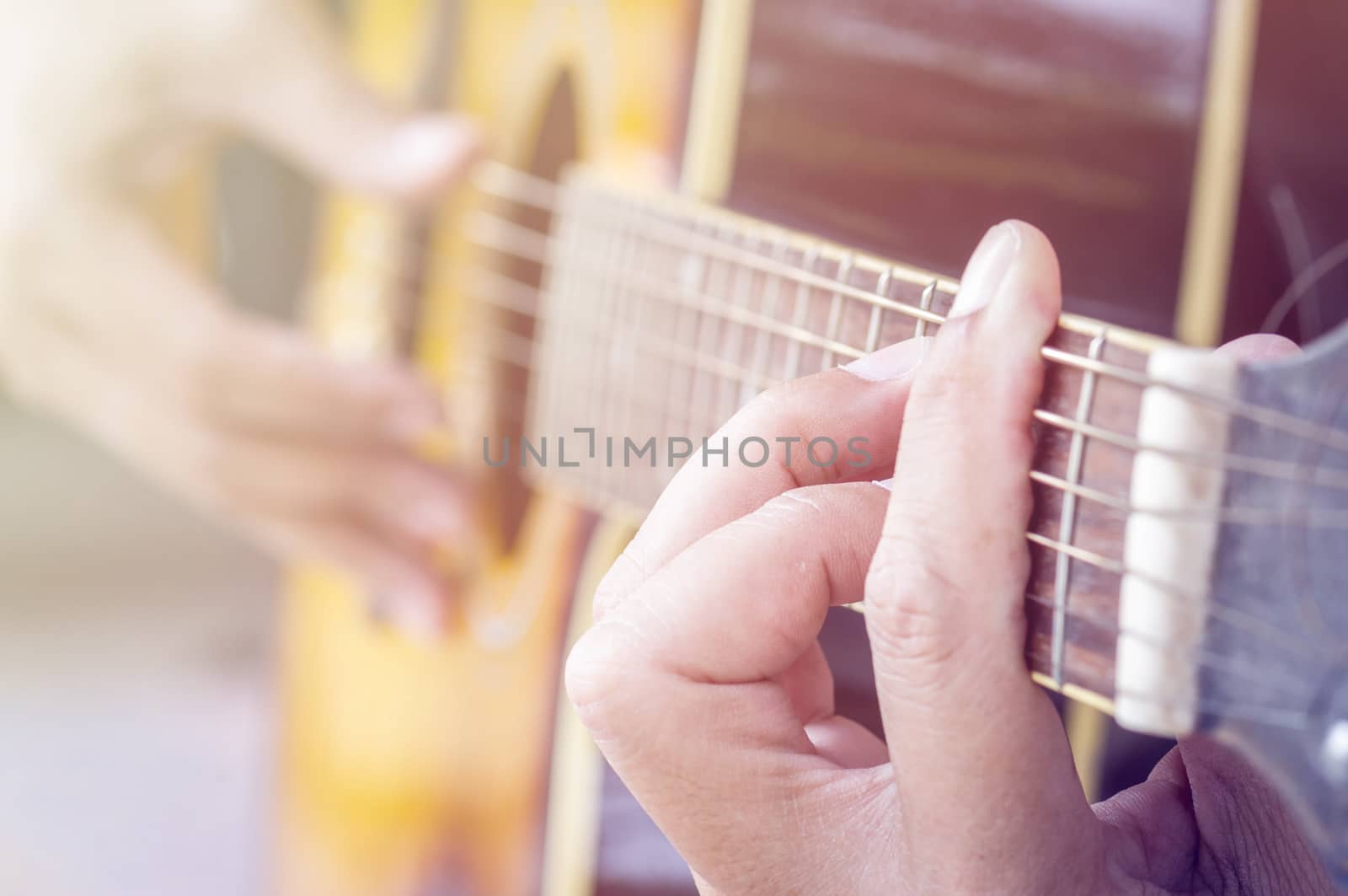 Hand playing acoustic guitar, by seksan44