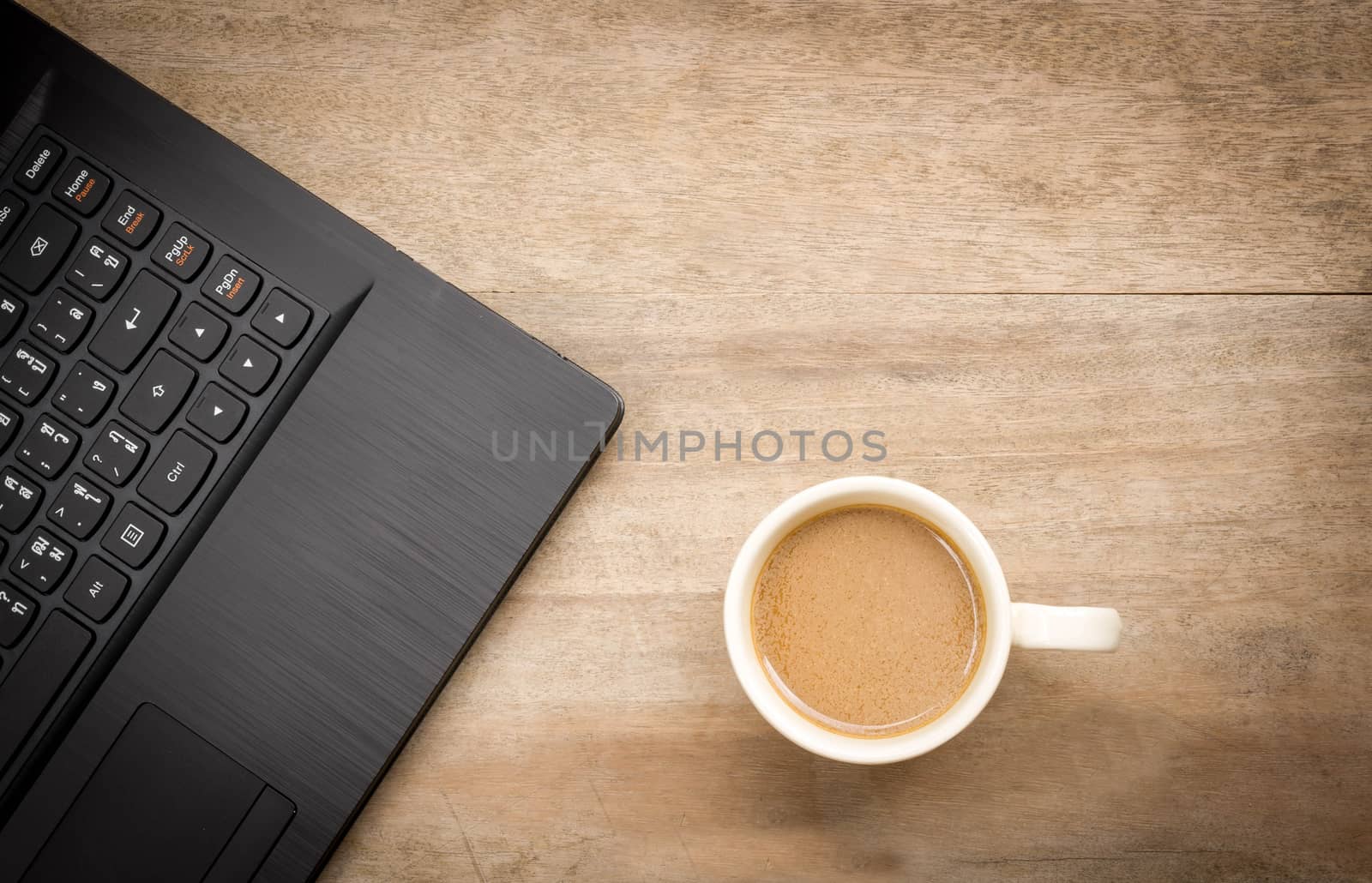 Cup of coffee and black notebook on wooden background.