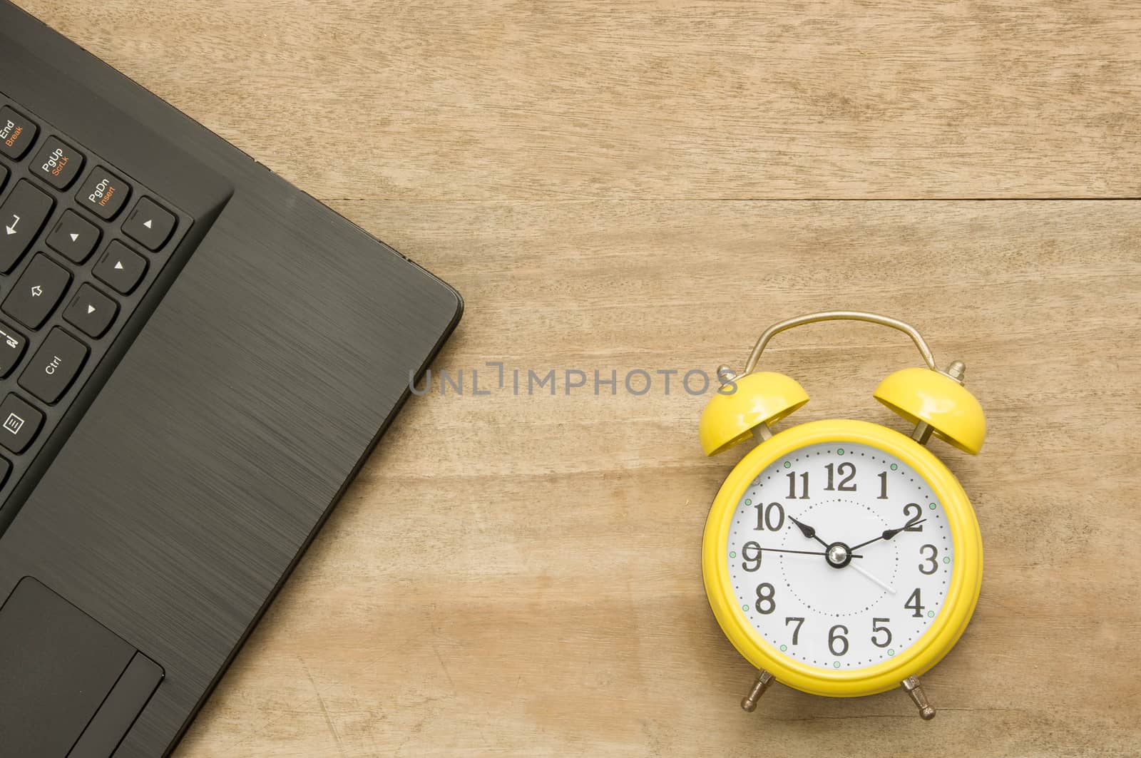 Black notebook  and yellow clock on wooden by seksan44