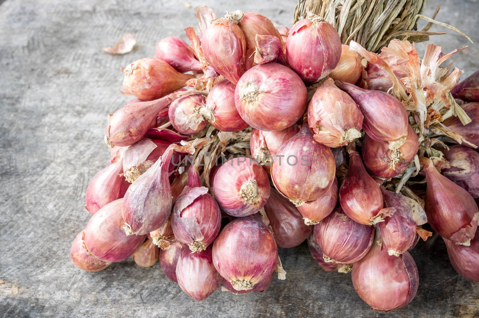 Many red onions on wooden background (Alliums, Alliaceae)