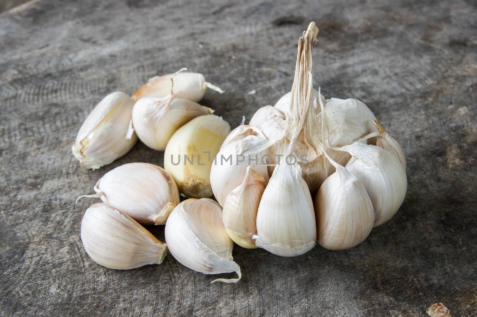 Close up of purple garlic on wooden background (Alliums, Alliaceae)