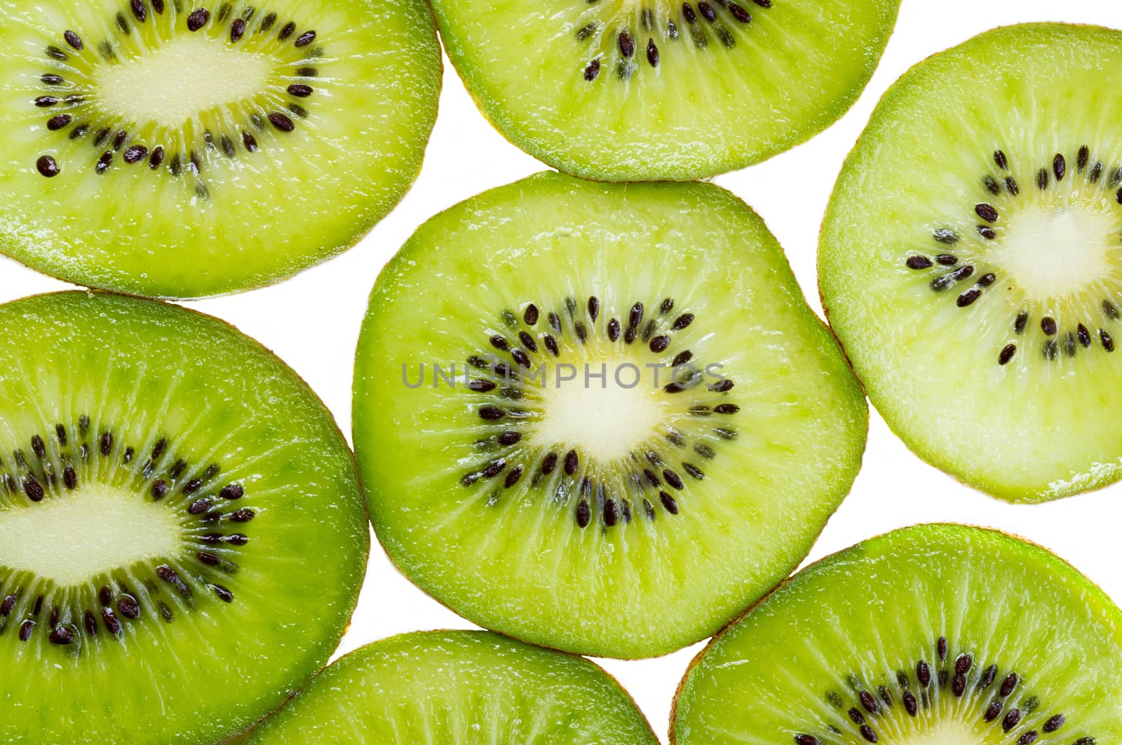 Many slices of kiwi fruit on white background.