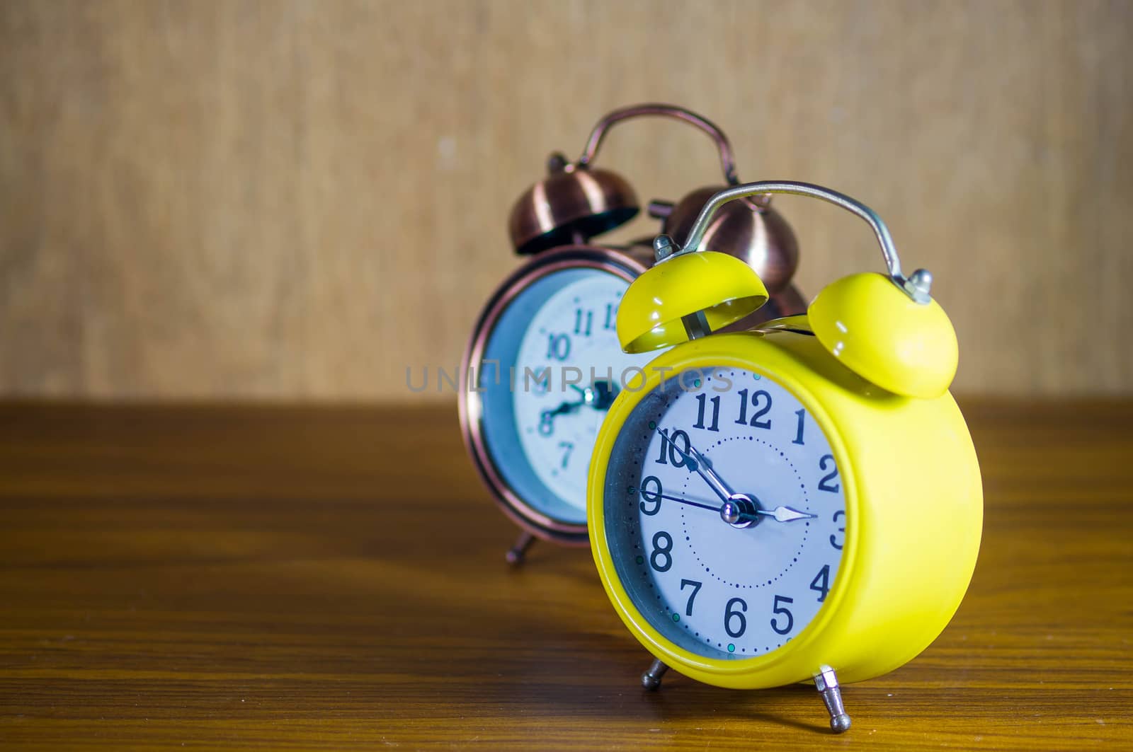 .retro alarm clock on table by seksan44