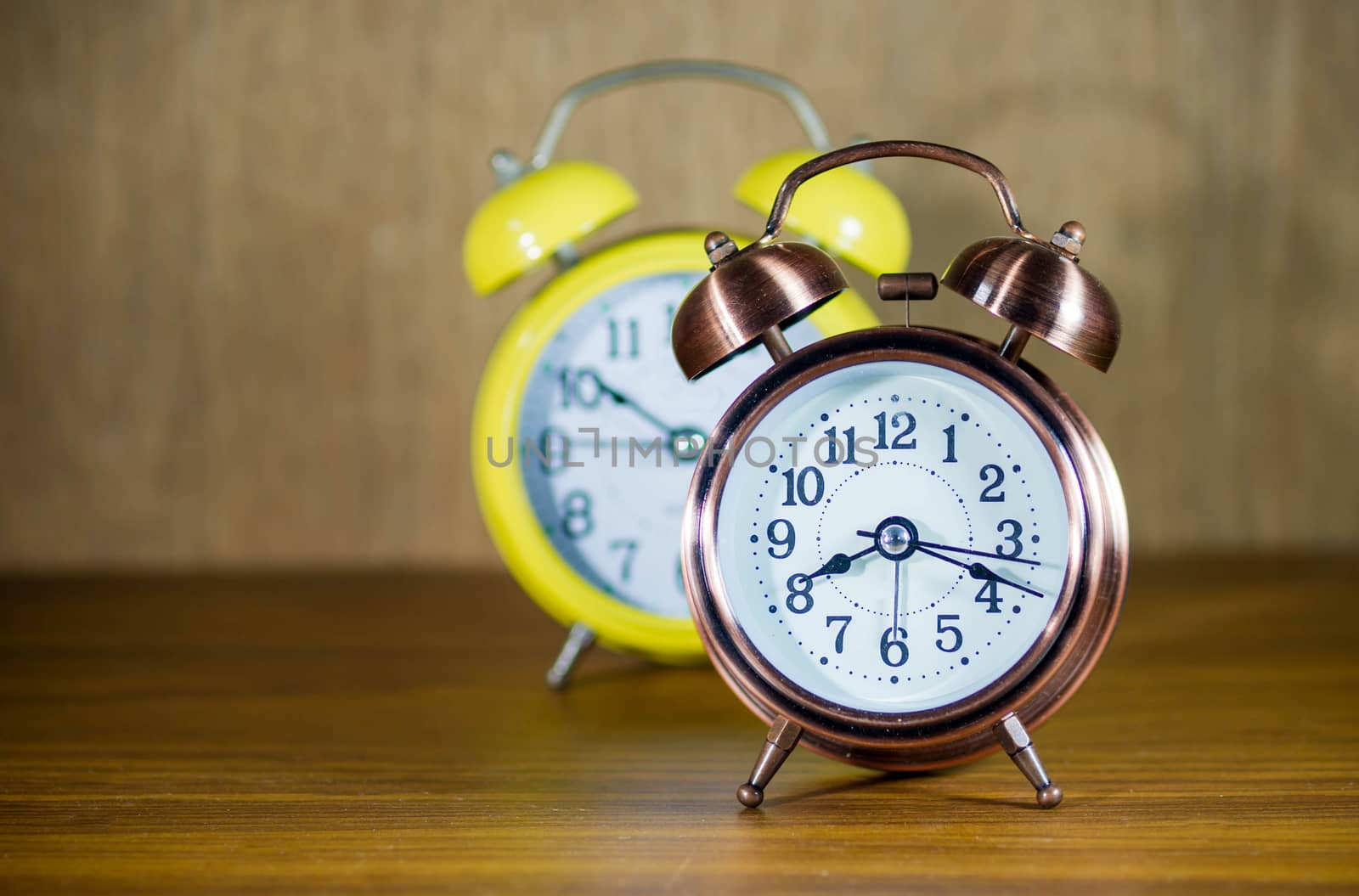 .retro alarm clock on table by seksan44