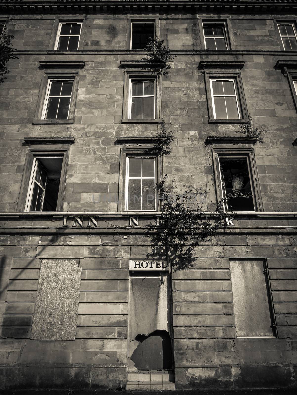 Black And White Image Of A Derelict And Boarded Up Hotel