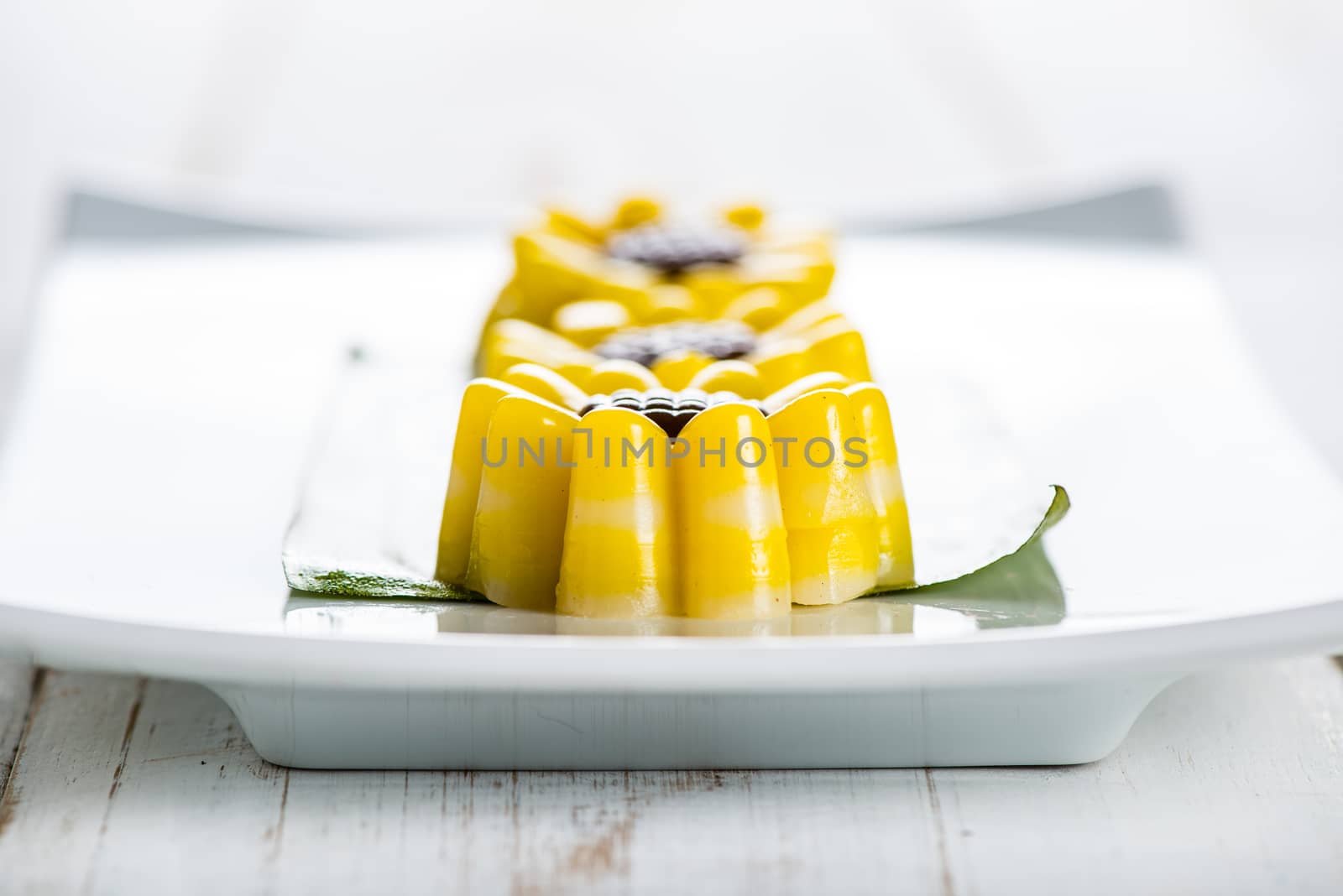 Yellow jelly dessert looking like a flower made with coconuts and pumpkin