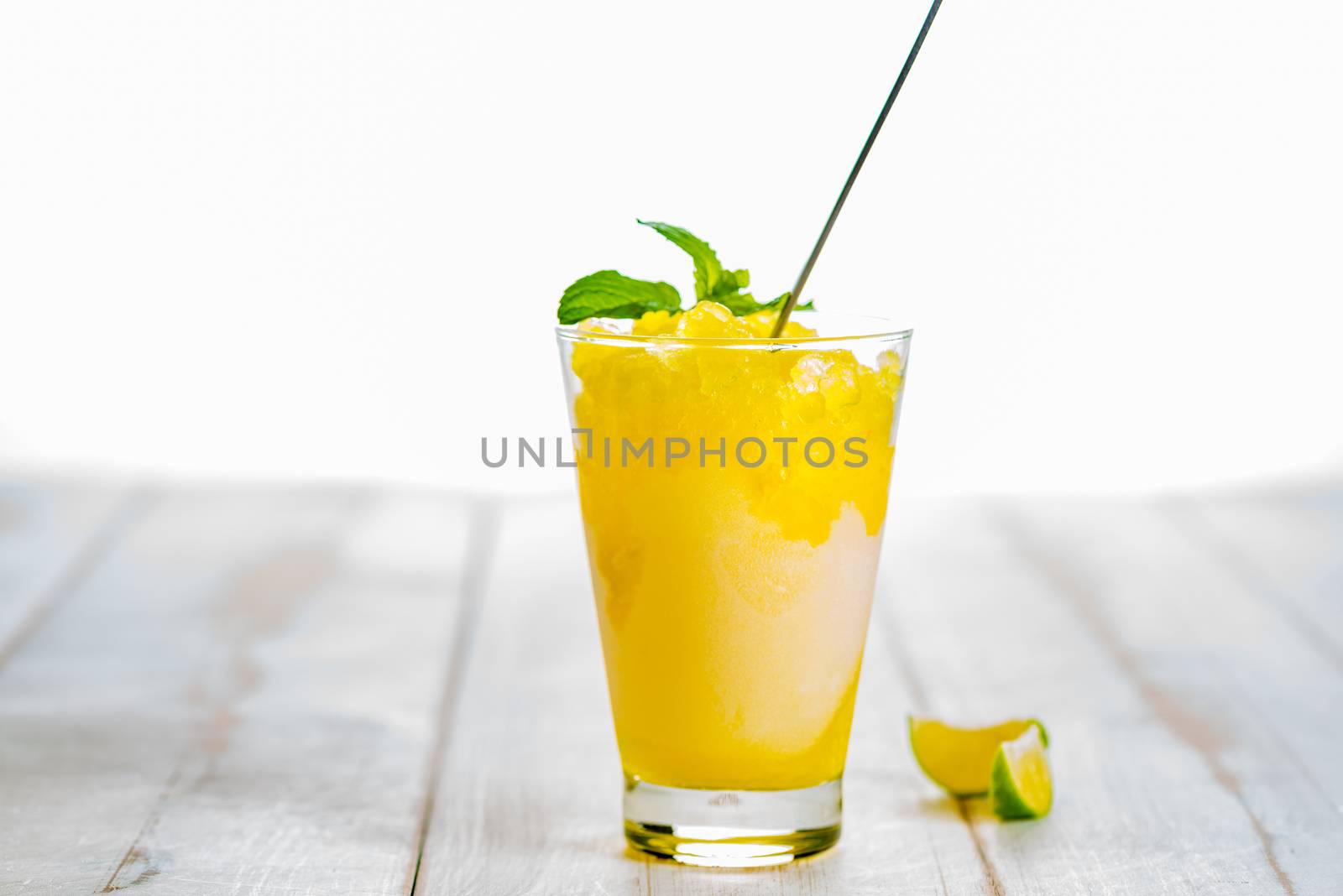 Lemon refreshing dessert in glass decorated with lemon and mint on white wood table