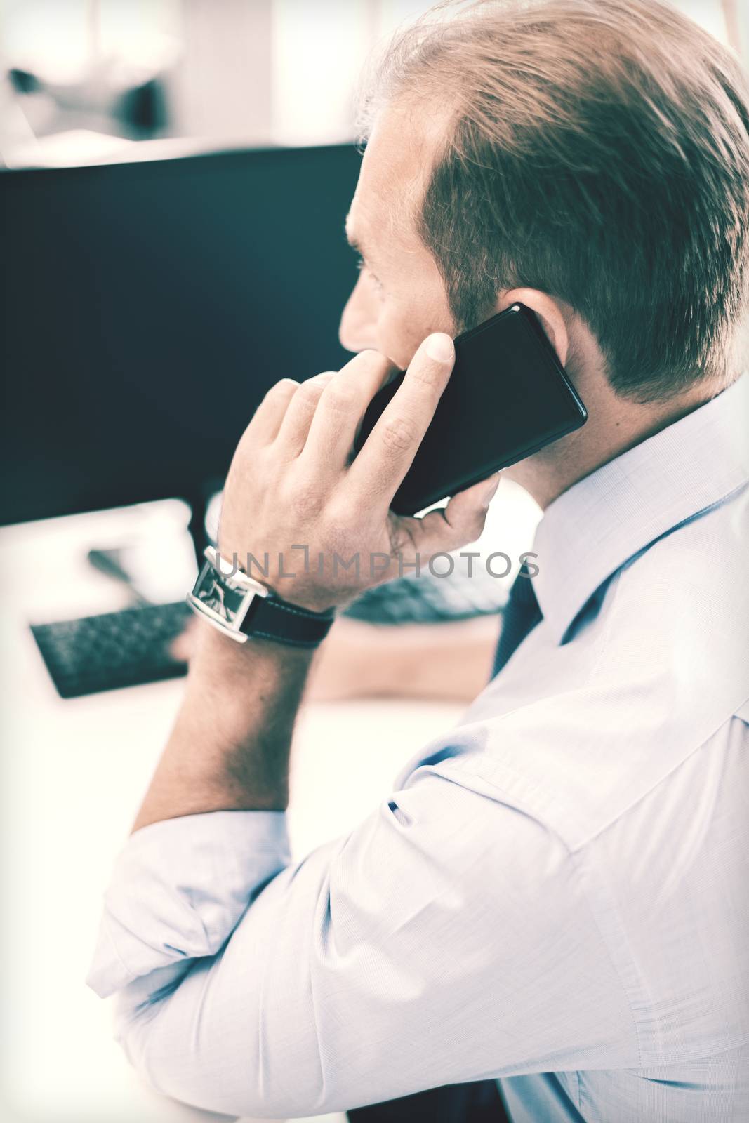 businessman with smartphone in office by dolgachov
