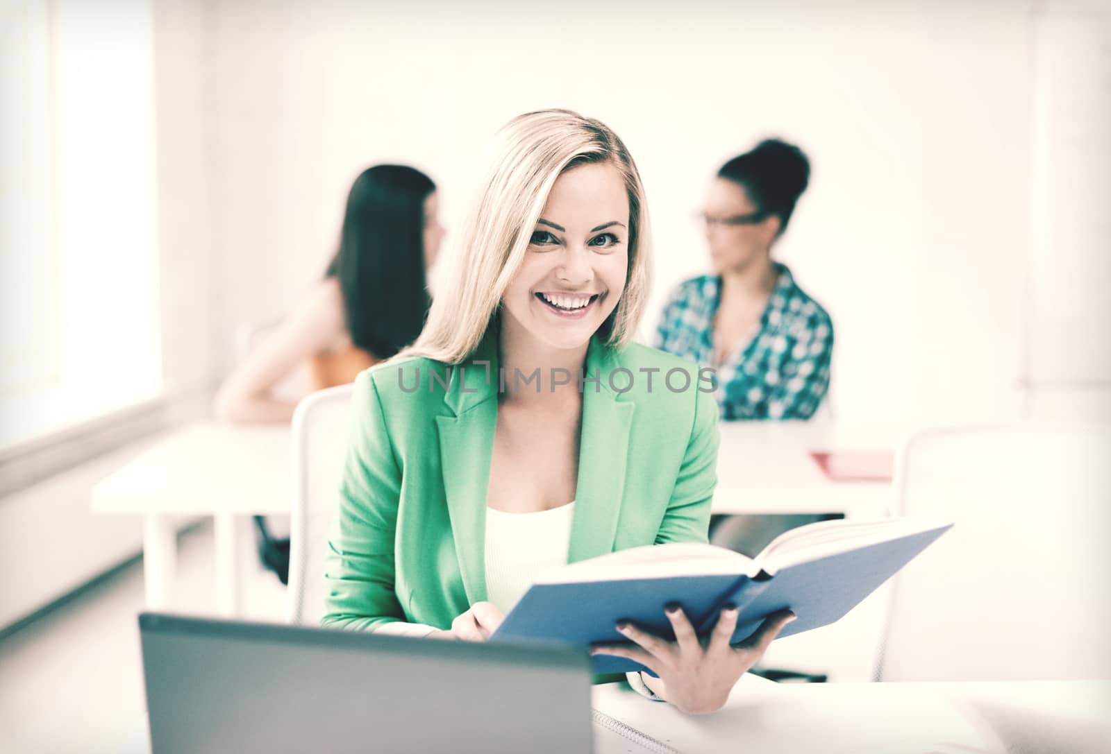 education concept - smiling young girl reading book at school