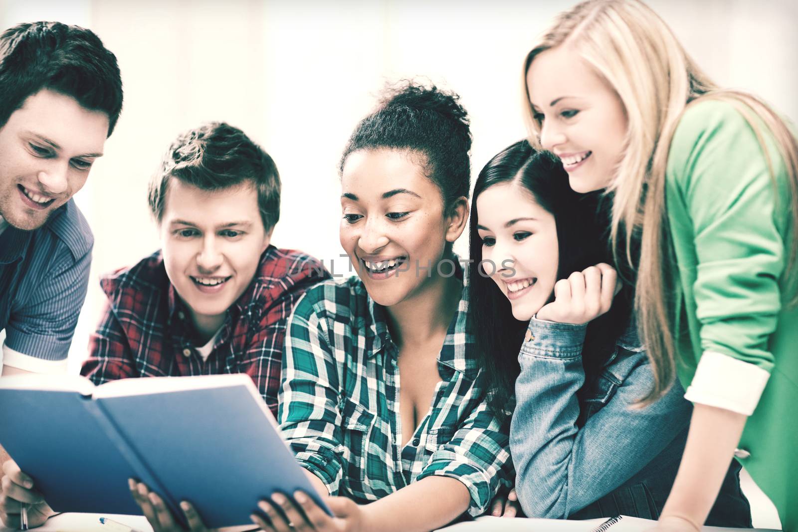 education concept - group of students reading book at school