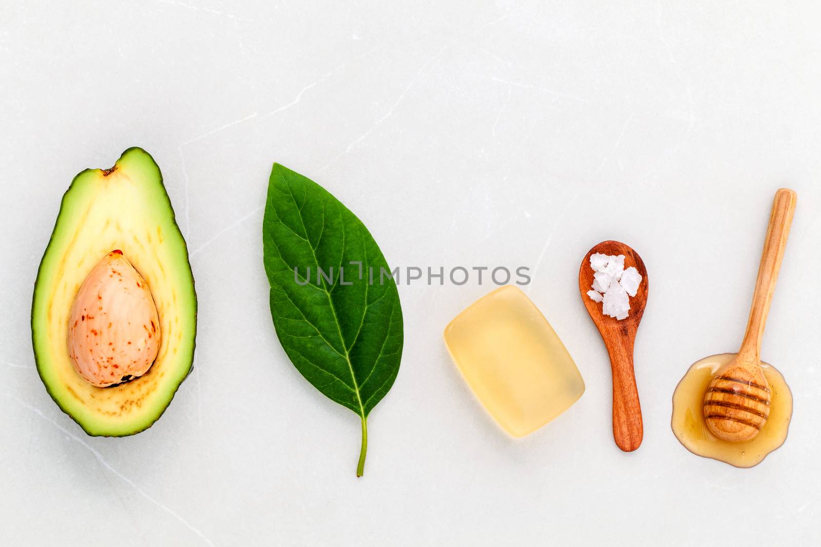 Alternative skin care  and scrub fresh  avocado , leaves ,sea salt soap and honey on marble background.