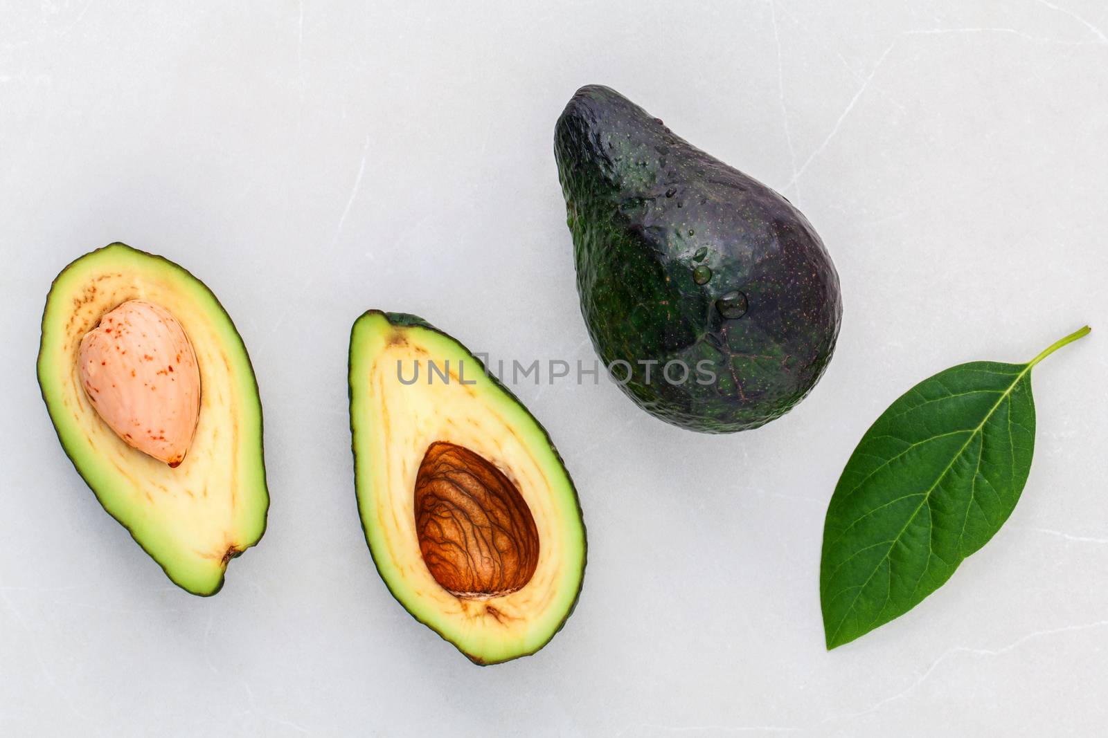 Alternative health care fresh  avocado and leaves on marble background.