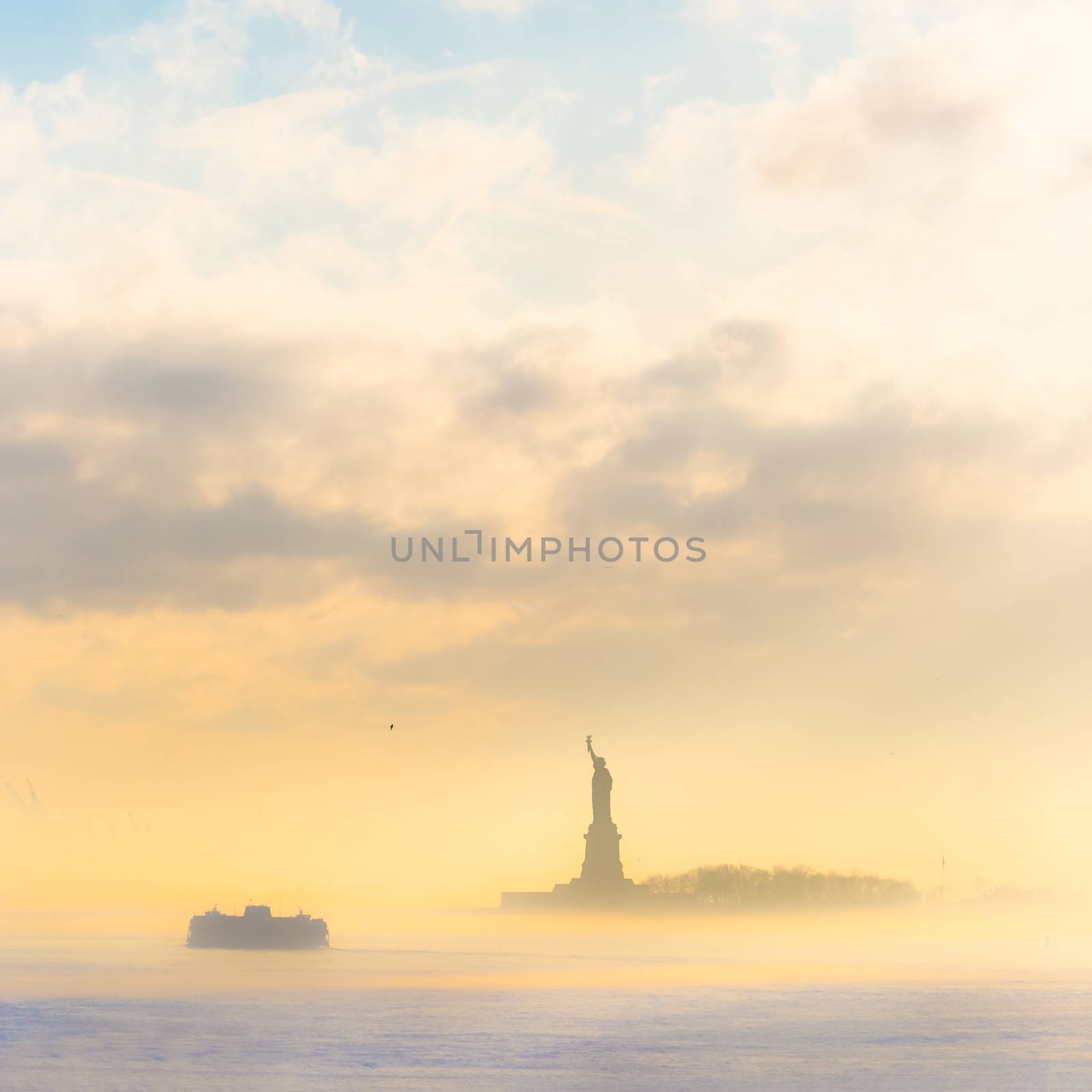 Staten Island Ferry cruises past the Statue of Liberty on a misty sunset. Manhattan, New York City, United States of America. Square composition. Copy space.
