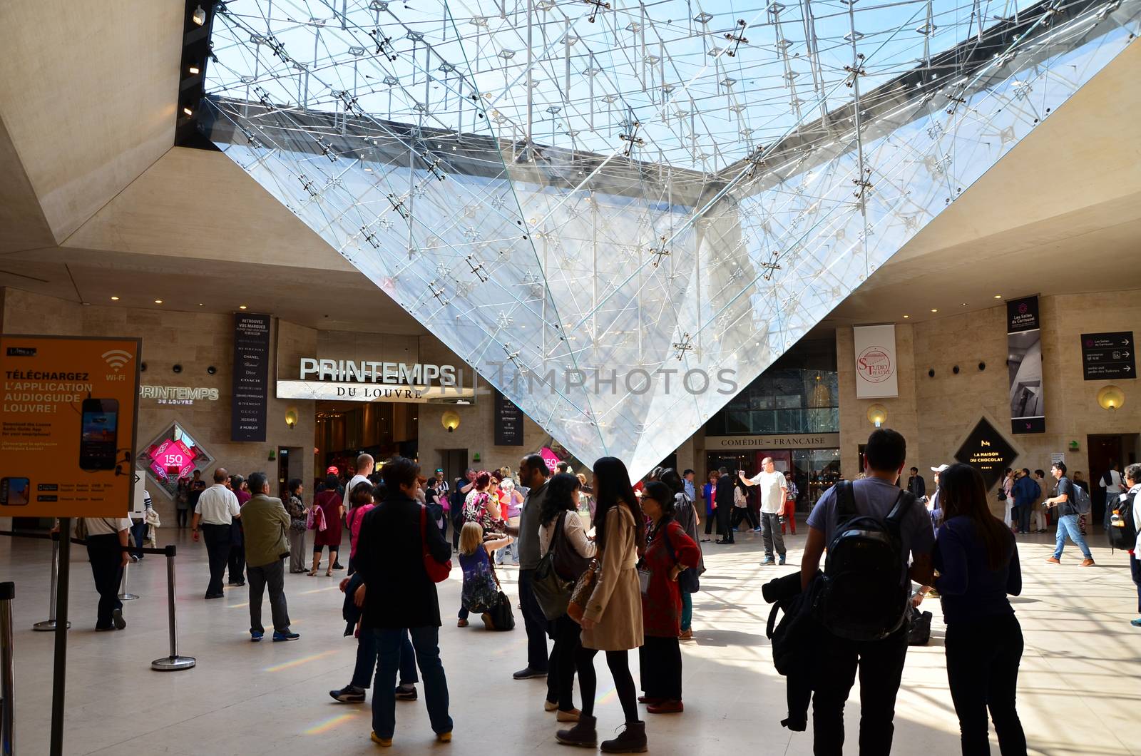 Paris, France - May 13, 2015: Tourists visit Inside the Louvres pyramid in Paris by siraanamwong