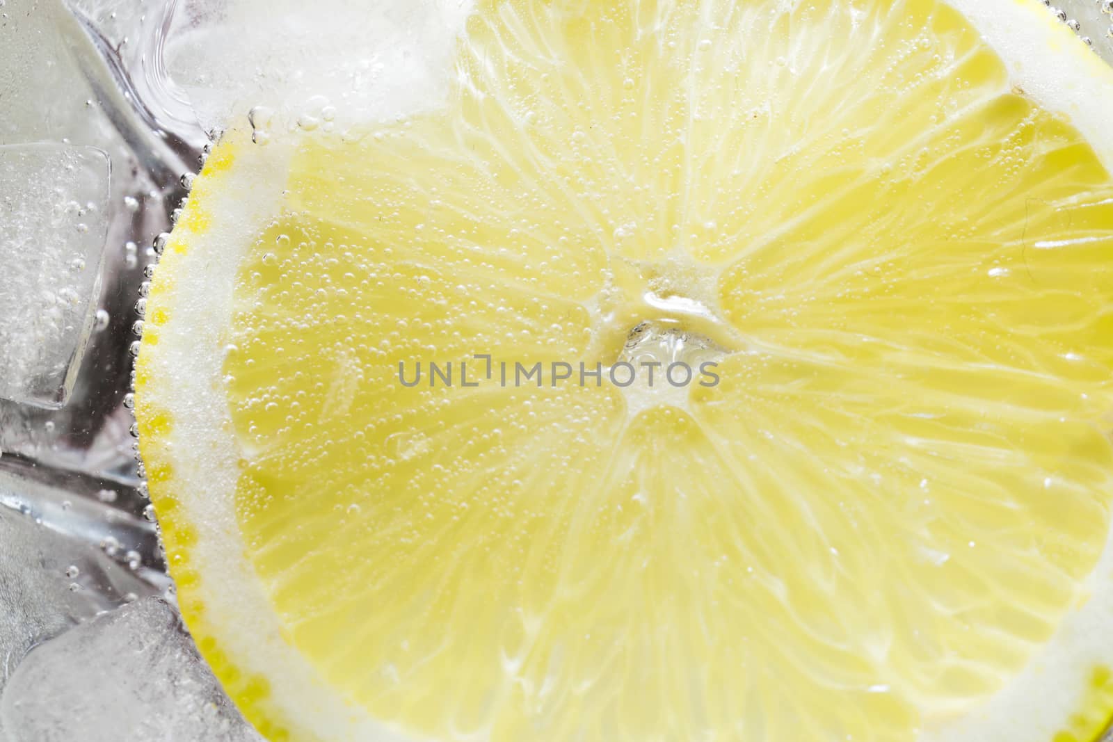 The photo depicts a lemon in bubbles