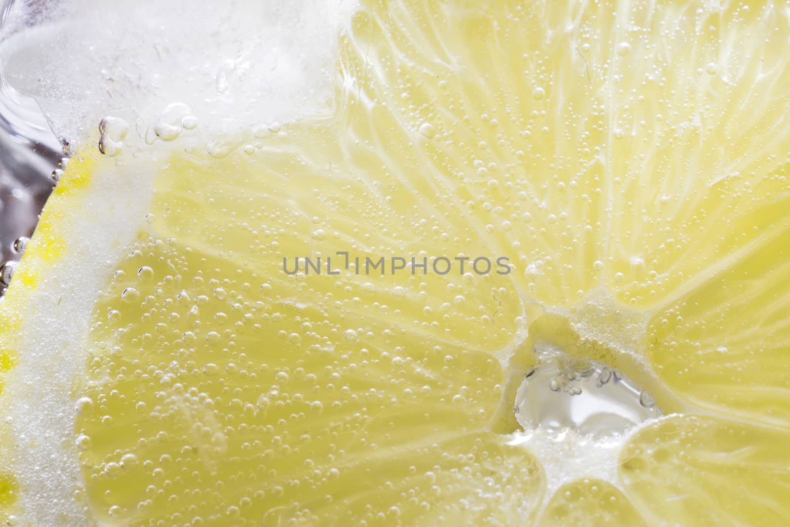 The photo depicts a lemon in bubbles