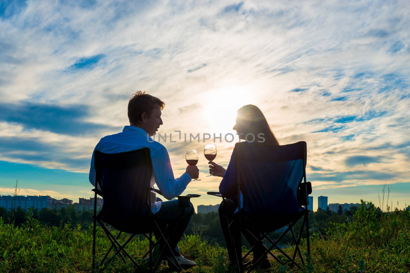 young married couple with a glass of wine at sunset