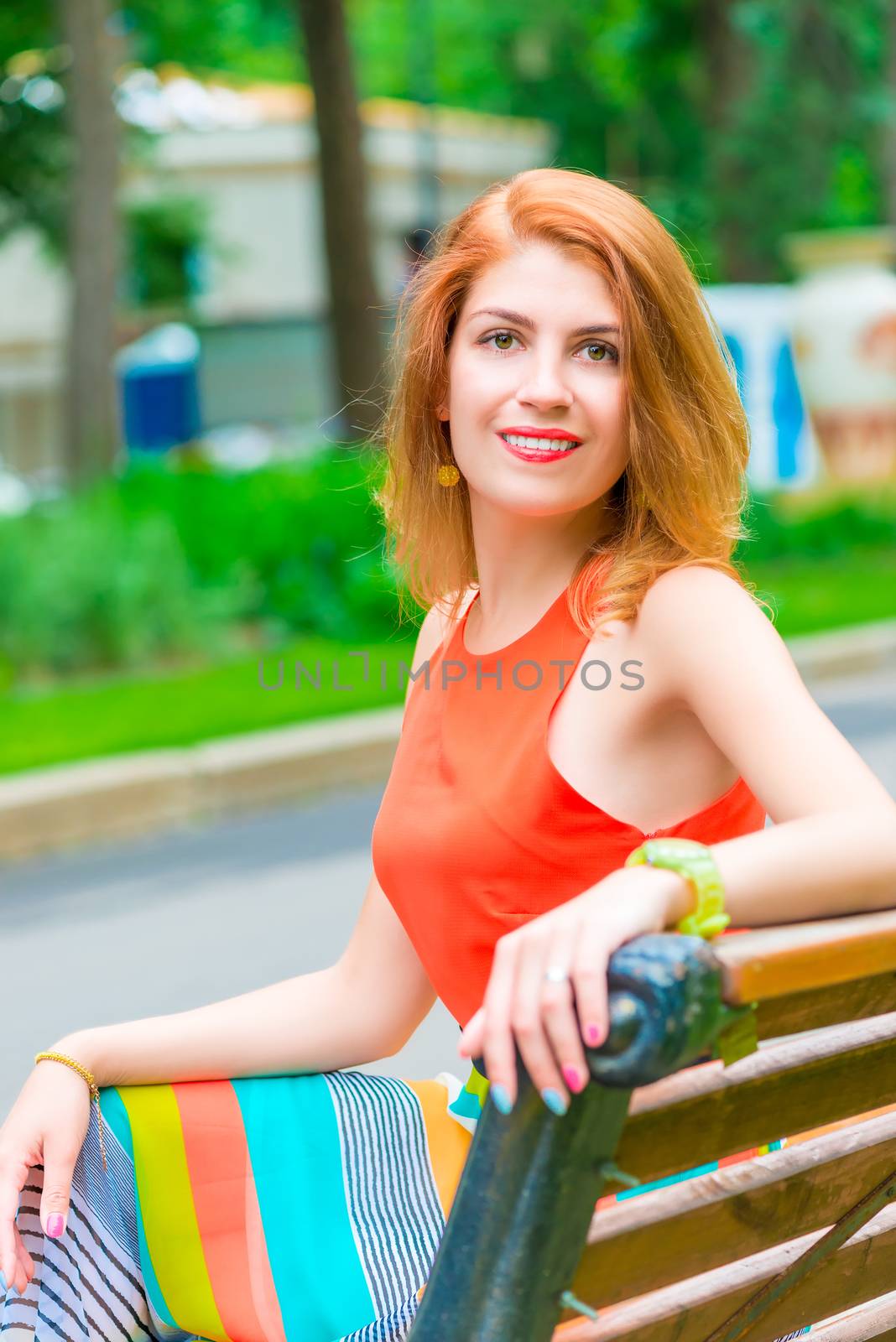 portrait of happy young girl sitting on a park bench by kosmsos111