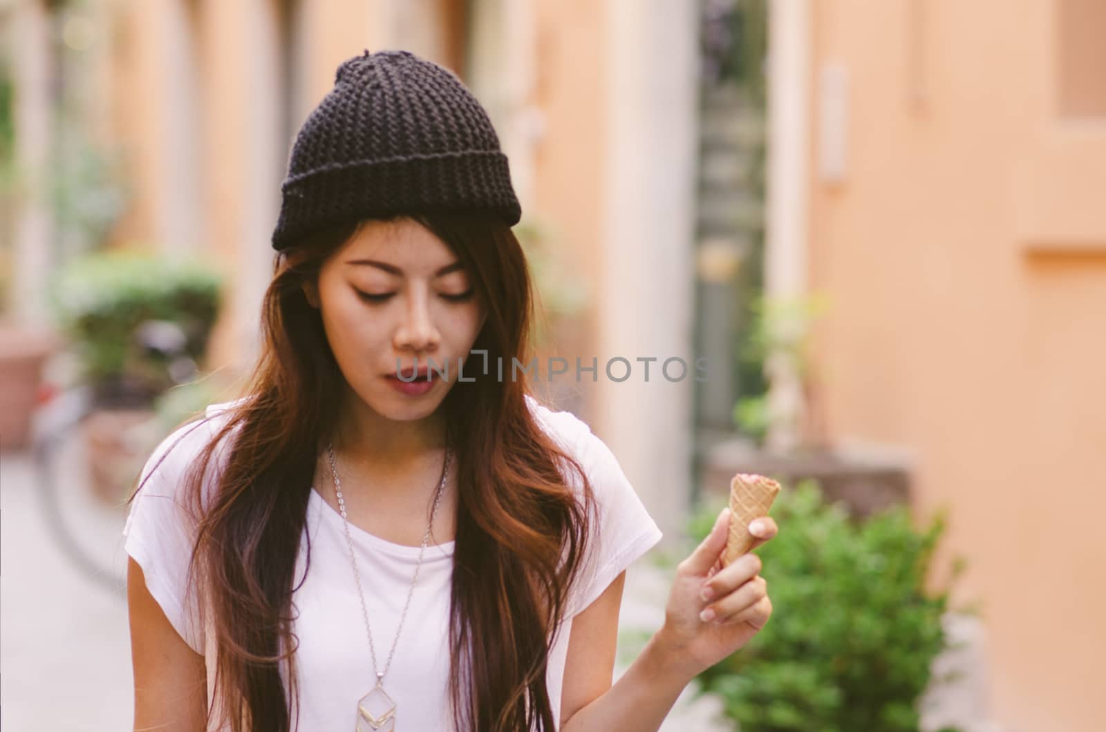 Hipster girl on the street and a half cone of ice cream